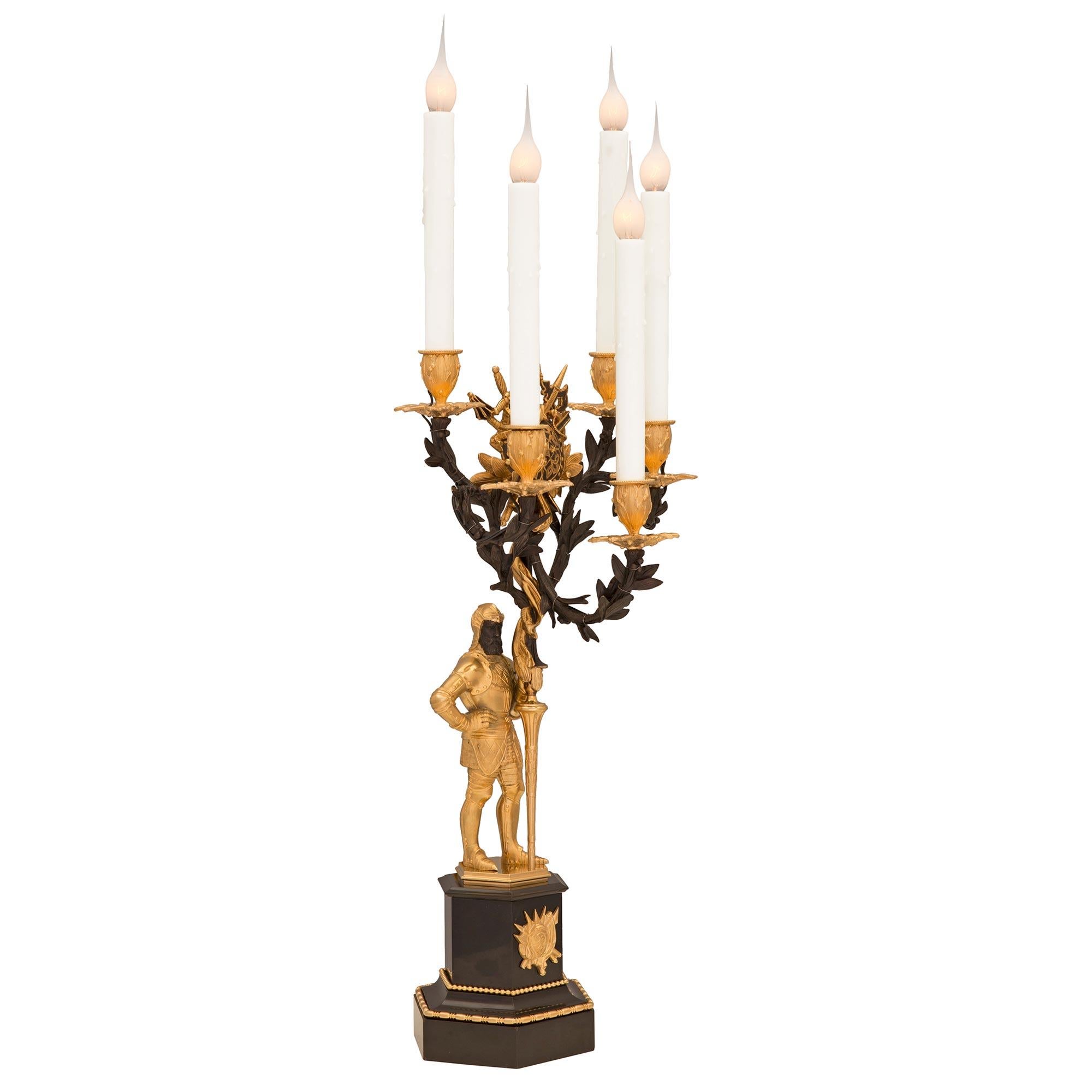 An impressive and high quality true pair of French 19th century Restauration st. patinated bronze, ormolu, and black Belgian marble candelabra lamps. Each five arm lamp is raised by a most decorative hexagonal black Belgian marble base with a fine