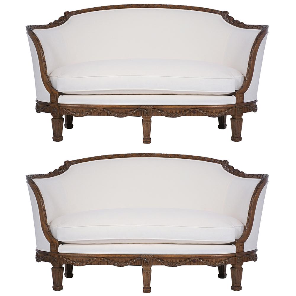 A remarkable pair of French 19th century Louis XVI canopy settees handcrafted out of walnut wood with its original walnut color and has only been waxed and polished developing a beautiful patina finish. These elegant settees feature finely carved