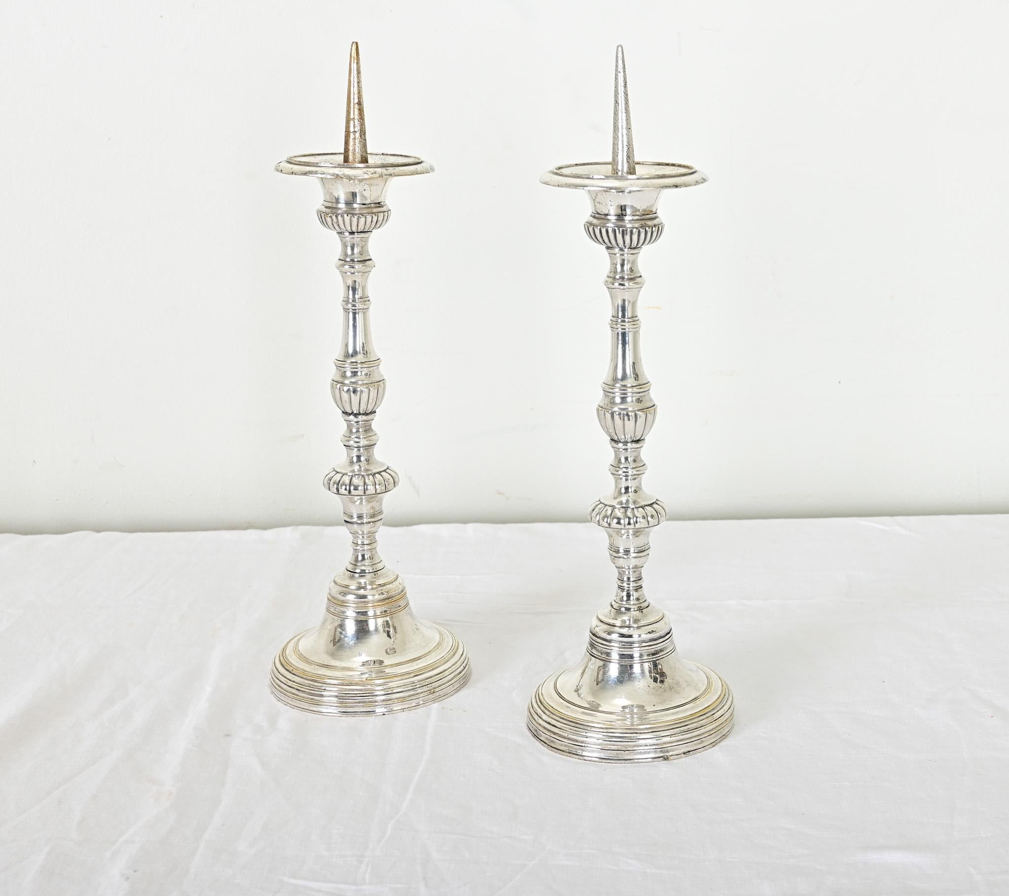 Una splendida coppia di candelabri francesi in stile Luigi XVI, del XIX secolo, in lastra d'argento scintillante. La base è fusa con eccezionali dettagli scanalati, dalla punta del cono fino alla struttura a reticolo del piede, e nonostante una