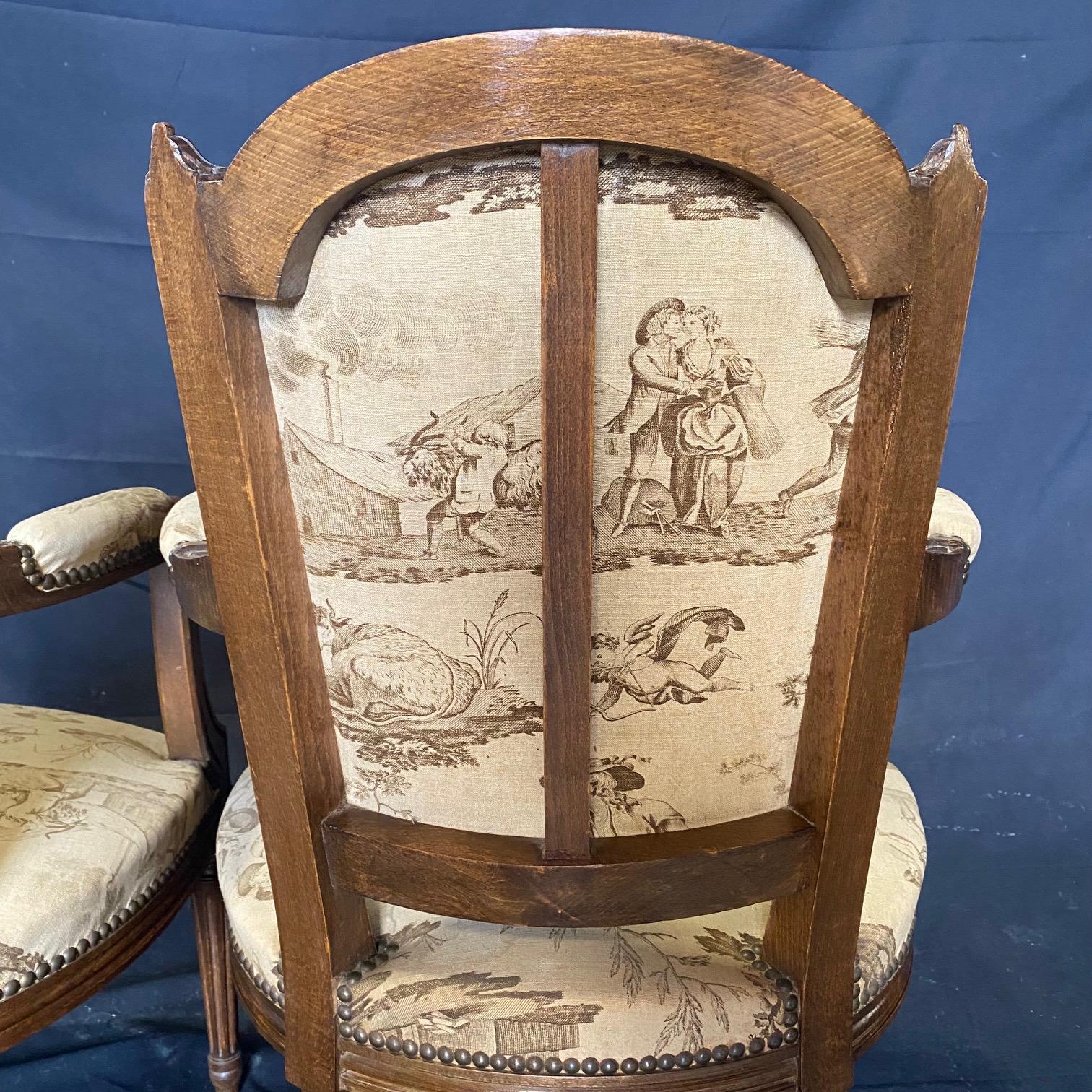 Rarely do you find original upholstery in as good shape as on these stunning early French toile armchairs or fauteuils.  Crafted in the 19th century, these walnut Louis XVI elegant arm chairs will add elegance to any room. A stunning pair of French