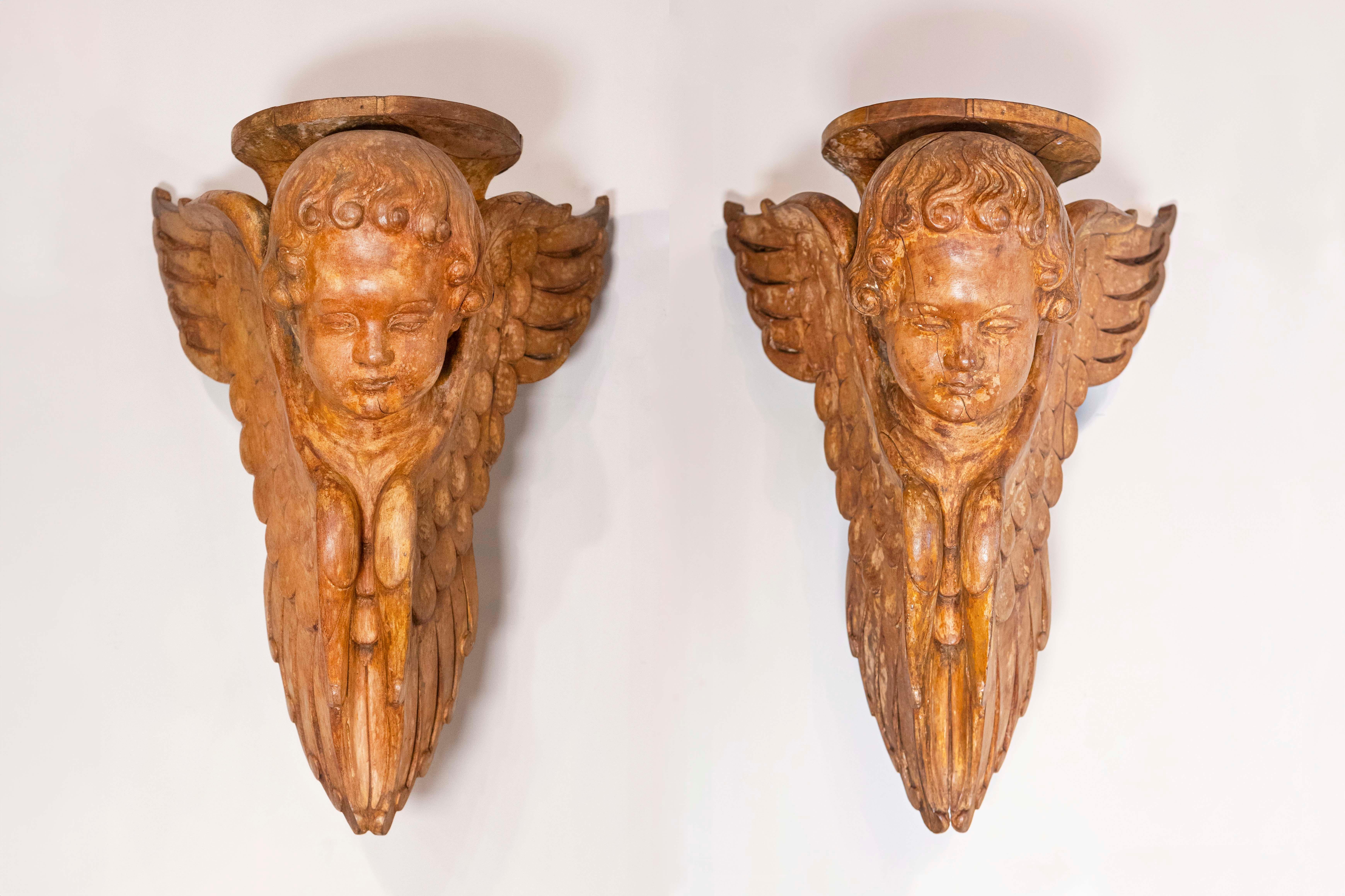 A pair of French wooden wall brackets from the 19th century, with carved cherubs. Born in France during the 19th century, this pair of wall brackets attracts our attention with its carved cherub figures each supporting a shelf. Their eyes