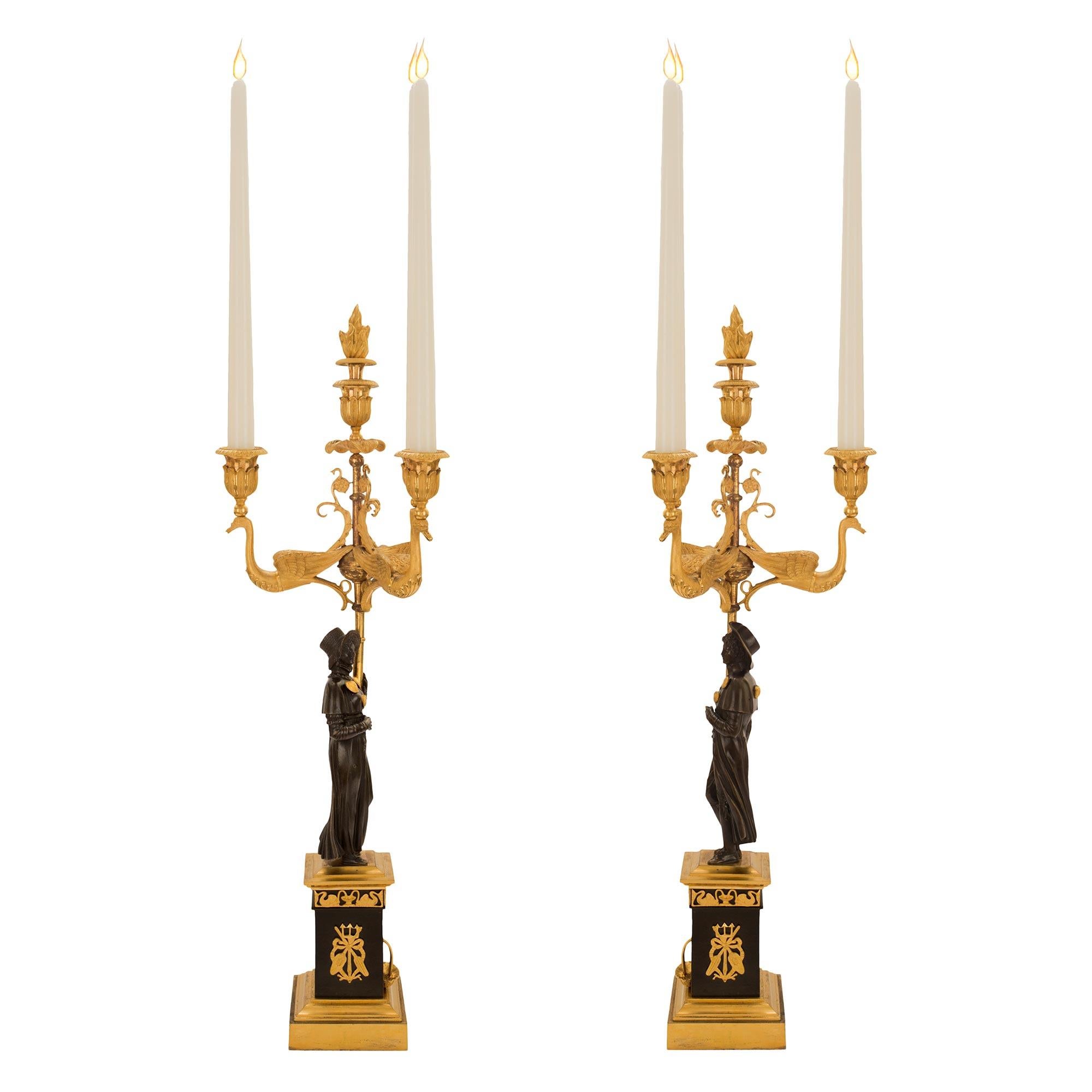 A high quality and stunning true pair of French 1st empire period, ca. 1810 patinated bronze and ormolu three light candelabras. Each candelabra is raised on a mottled square ormolu base. Above is a square bronze plinth decorated with ormolu
