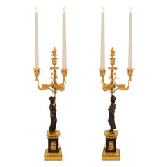 Coppia di candelabri francesi a tre luci in bronzo e ormolu del primo periodo dell'Impero