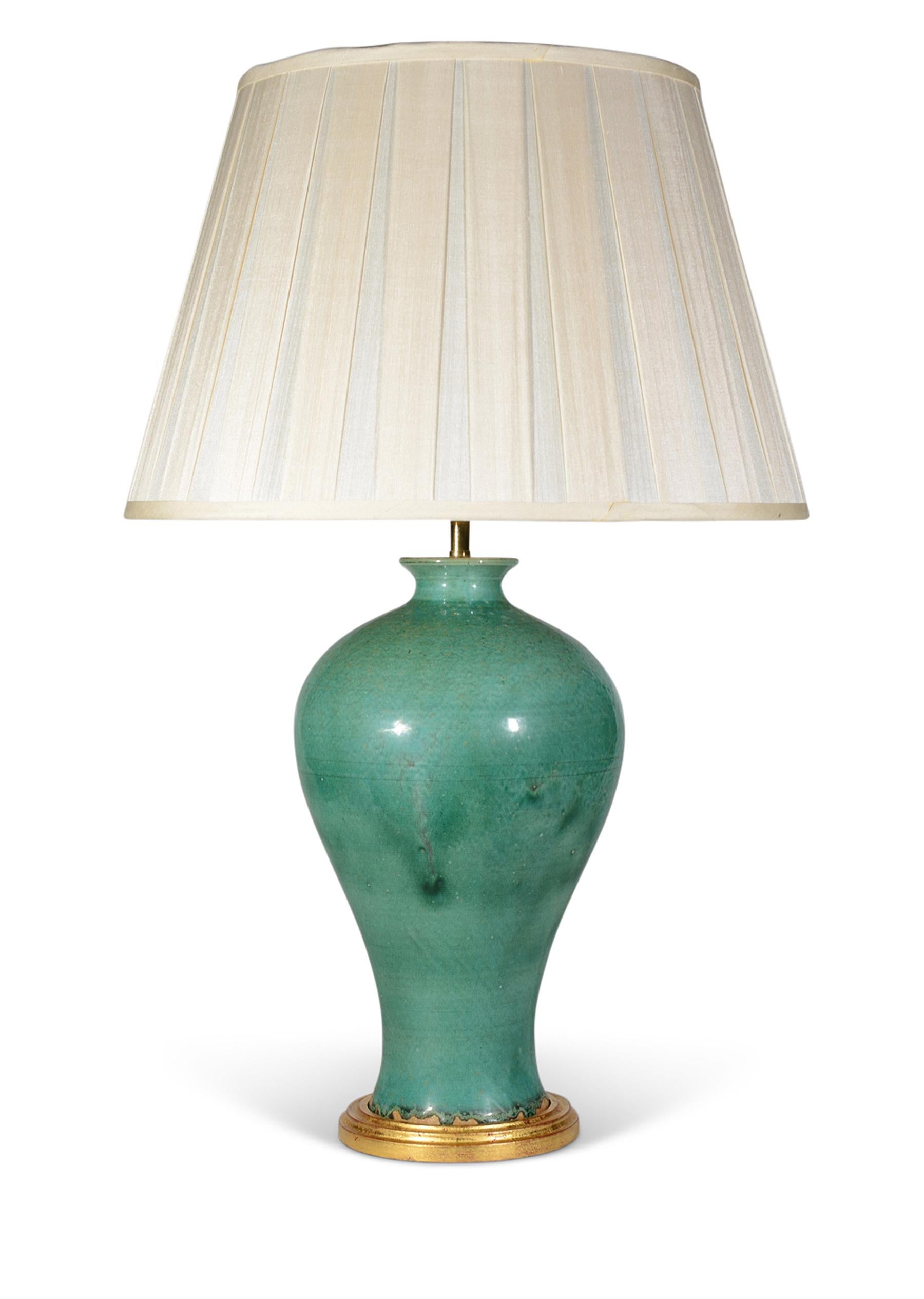 A pair of mid 20th century French ceramic baluster vases, with wonderful green drip glaze decoration, now mounted as lamps with hand gilded turned bases.

Height of vases: 14 1/2 in (36 cm) including giltwood bases, excluding electrical fitments and
