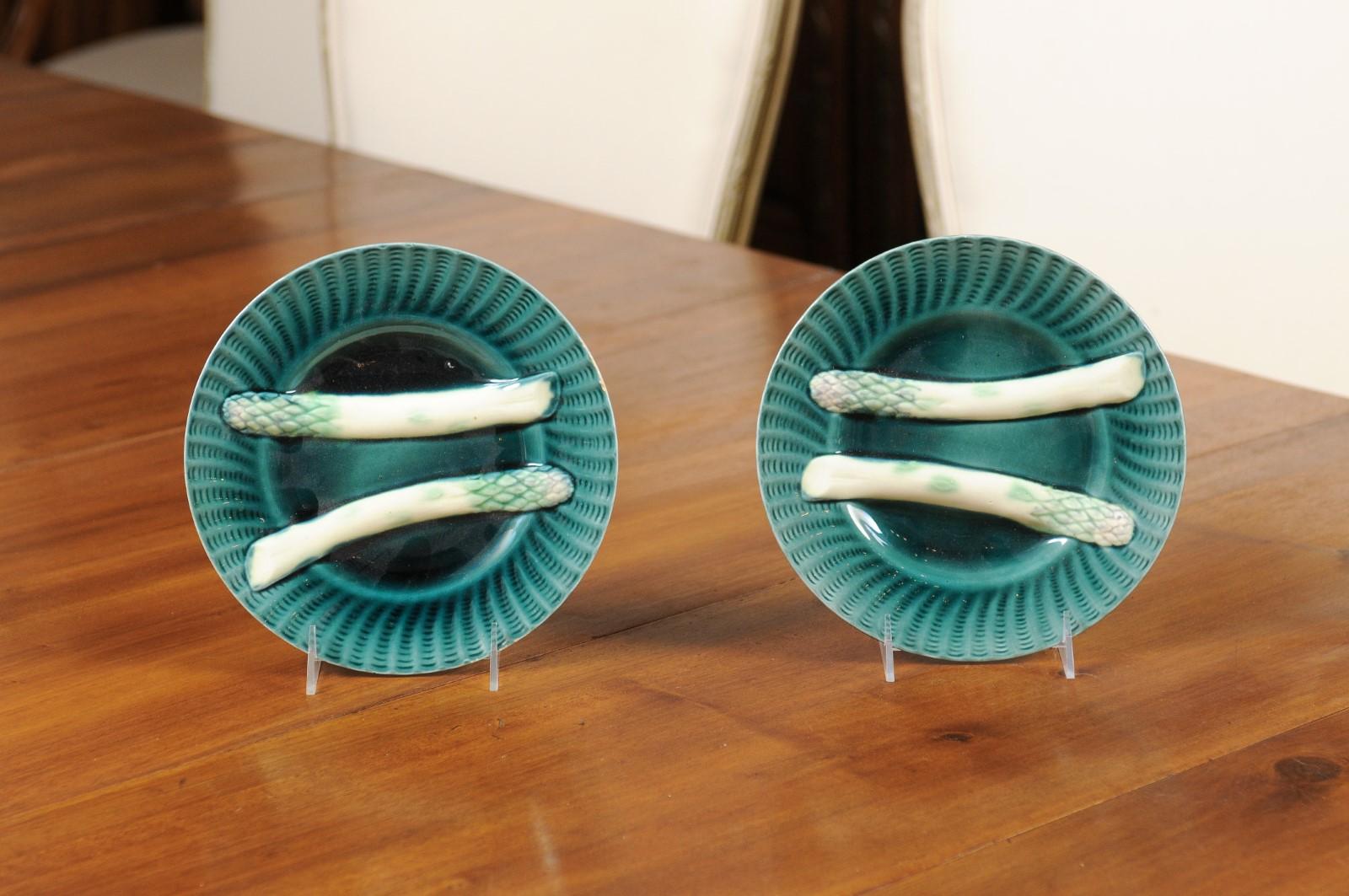 A pair of French asparagus plates from the 20th century, with aqua ground and rippled accents. Created in France during the 20th century, each of this pair of asparagus plates features an aqua ground adorned with rippled patterns on the edge,