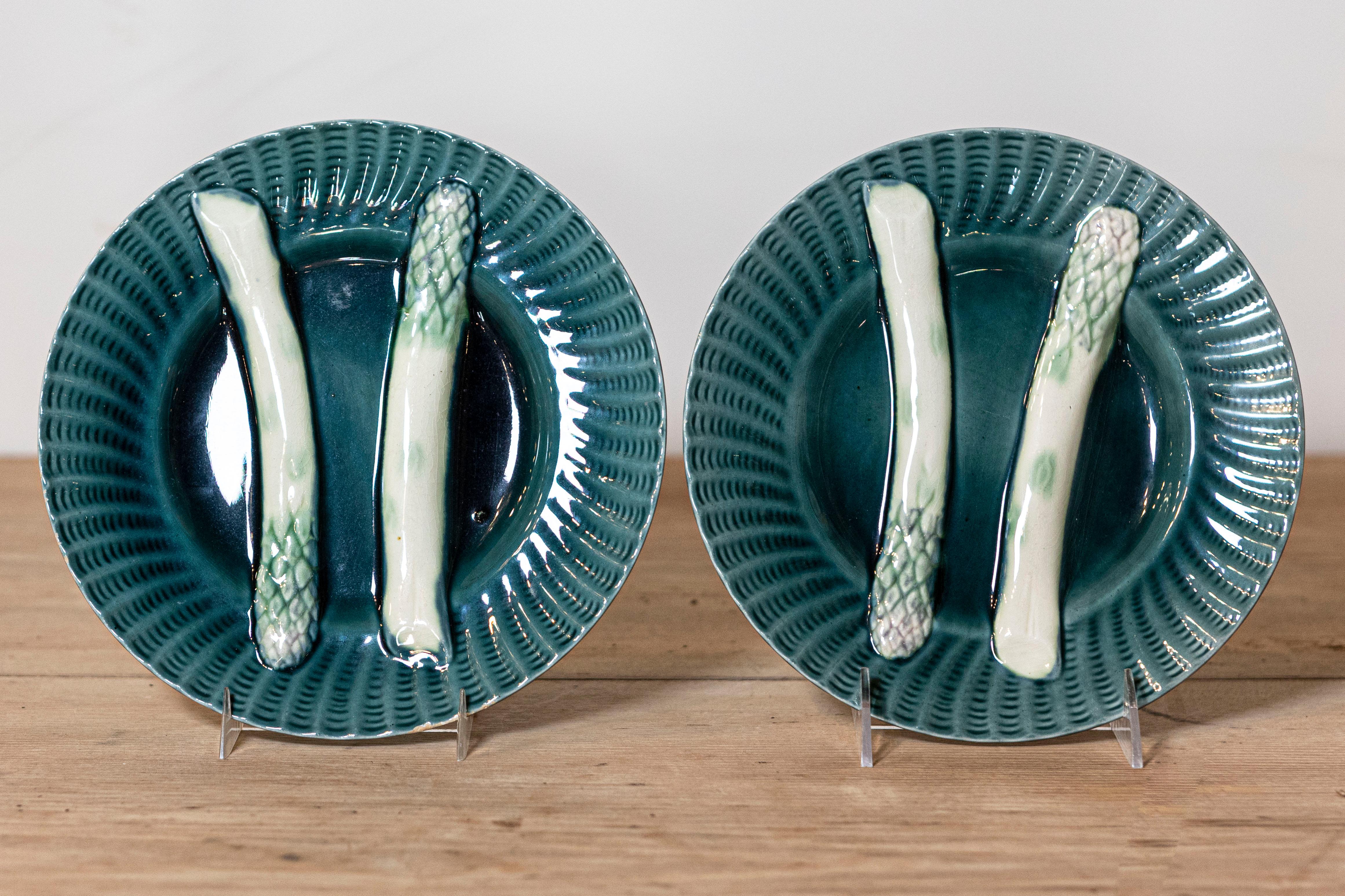 Paire d'assiettes à asperges françaises du 20e siècle, avec fond aqua et accents ondulés. Créée en France au cours du XXe siècle, cette paire d'assiettes à asperges présente un fond aqua orné de motifs ondulés sur le bord, entourant deux petites