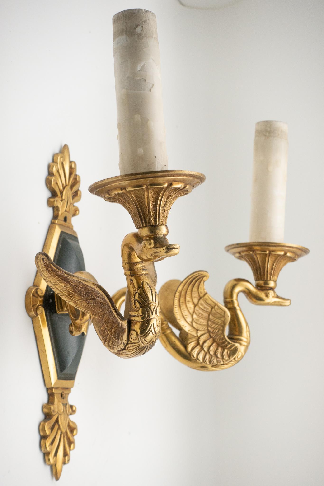 Pair of French 1940s bronze empire style swan sconces. We have 3 pairs available. Measures: 11.5