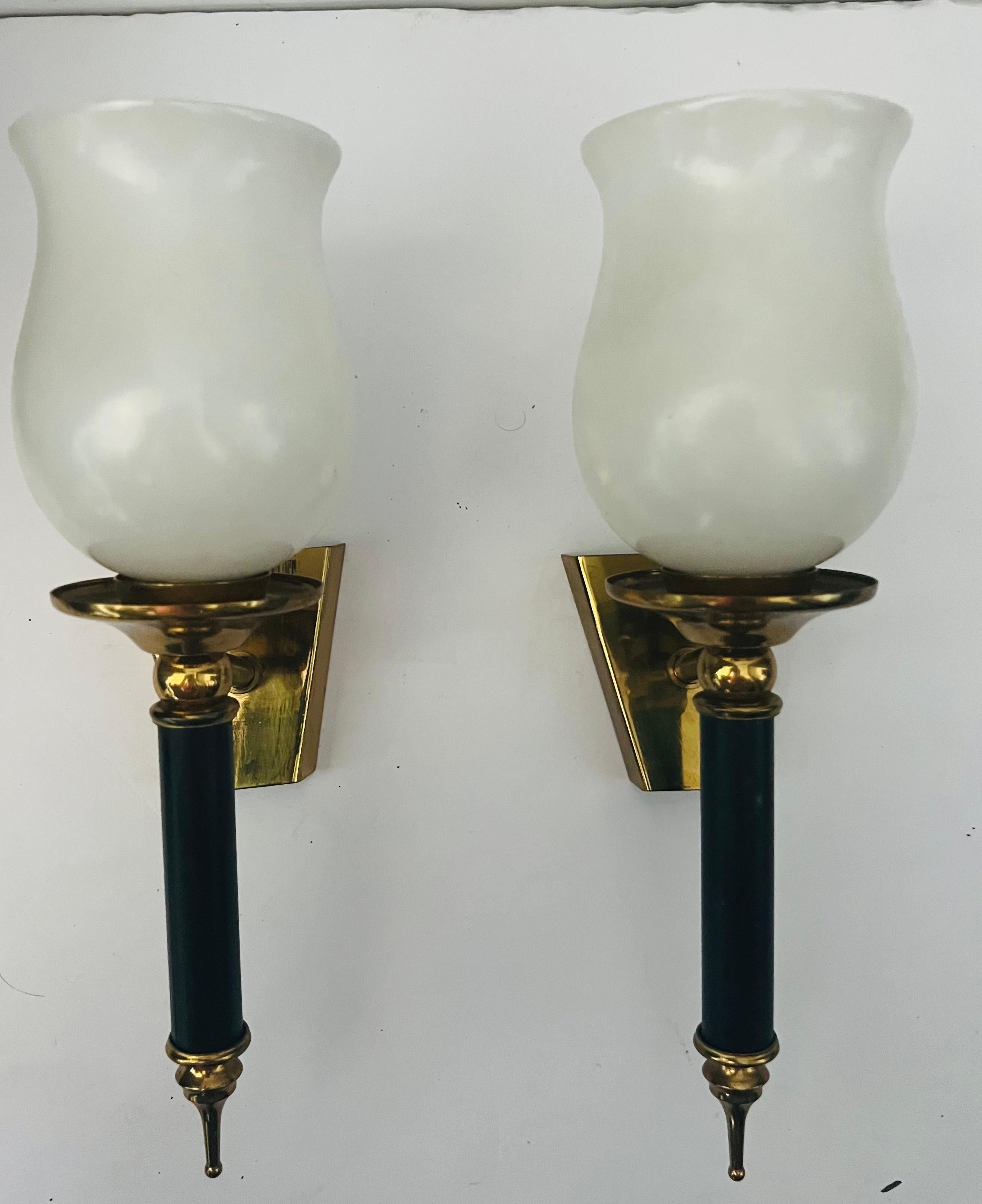 A wonderful pair of a French 1950s Regency wall
Sconces with brass and black enamel fixtures holding white tulip glass shades. Newly rewired.