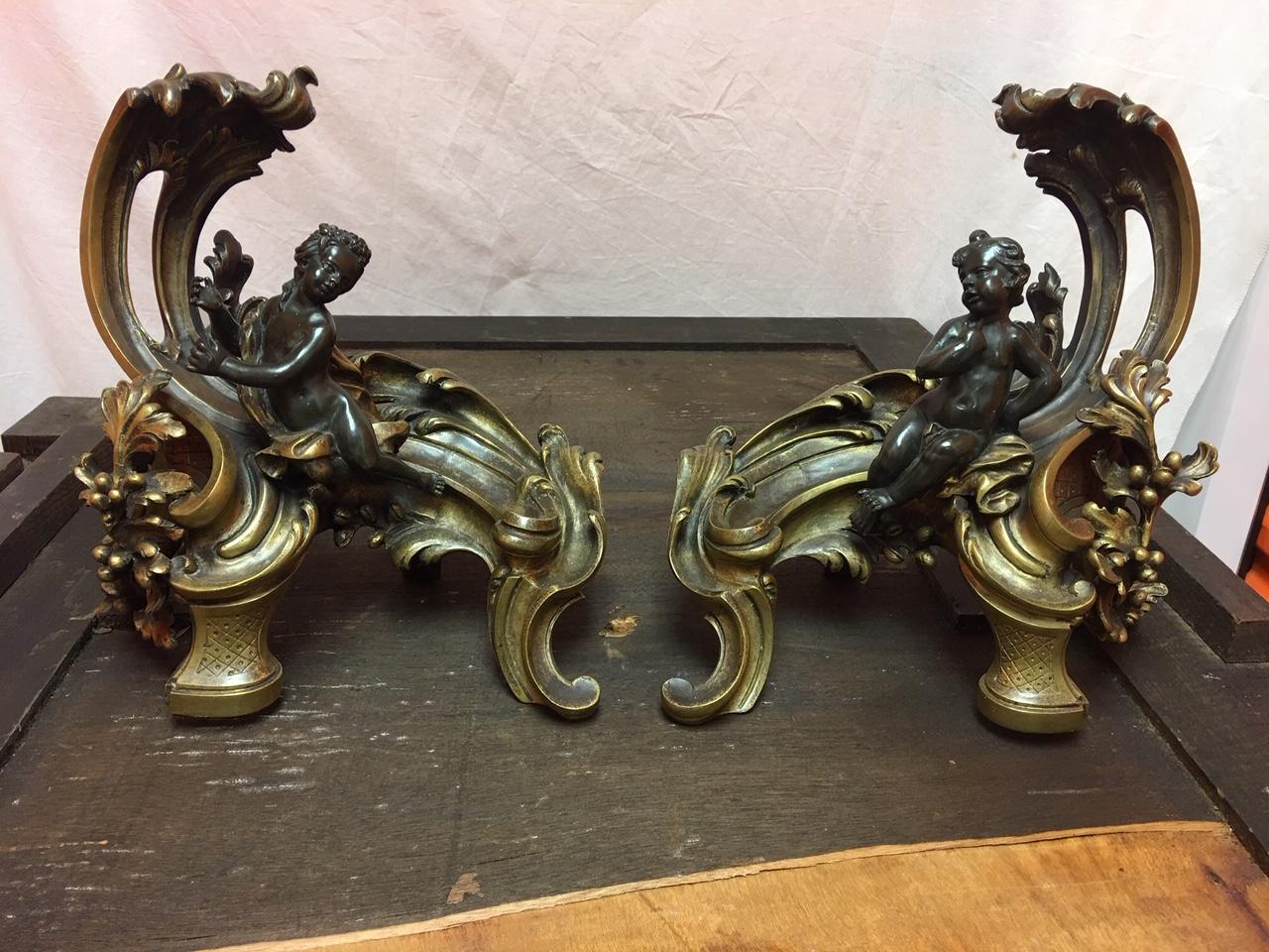 Pair of French acanthus leaves figural cherub chenets, 19th century.