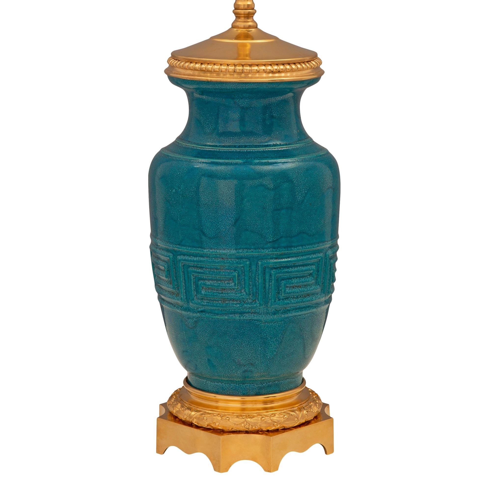 Une paire exceptionnelle de lampes en porcelaine émaillée bleu sarcelle et en bronze doré, de fabrication française et asiatique, attribuée à Théodore Deck. Chaque lampe est surélevée par une élégante base carrée en bronze doré, avec des coins