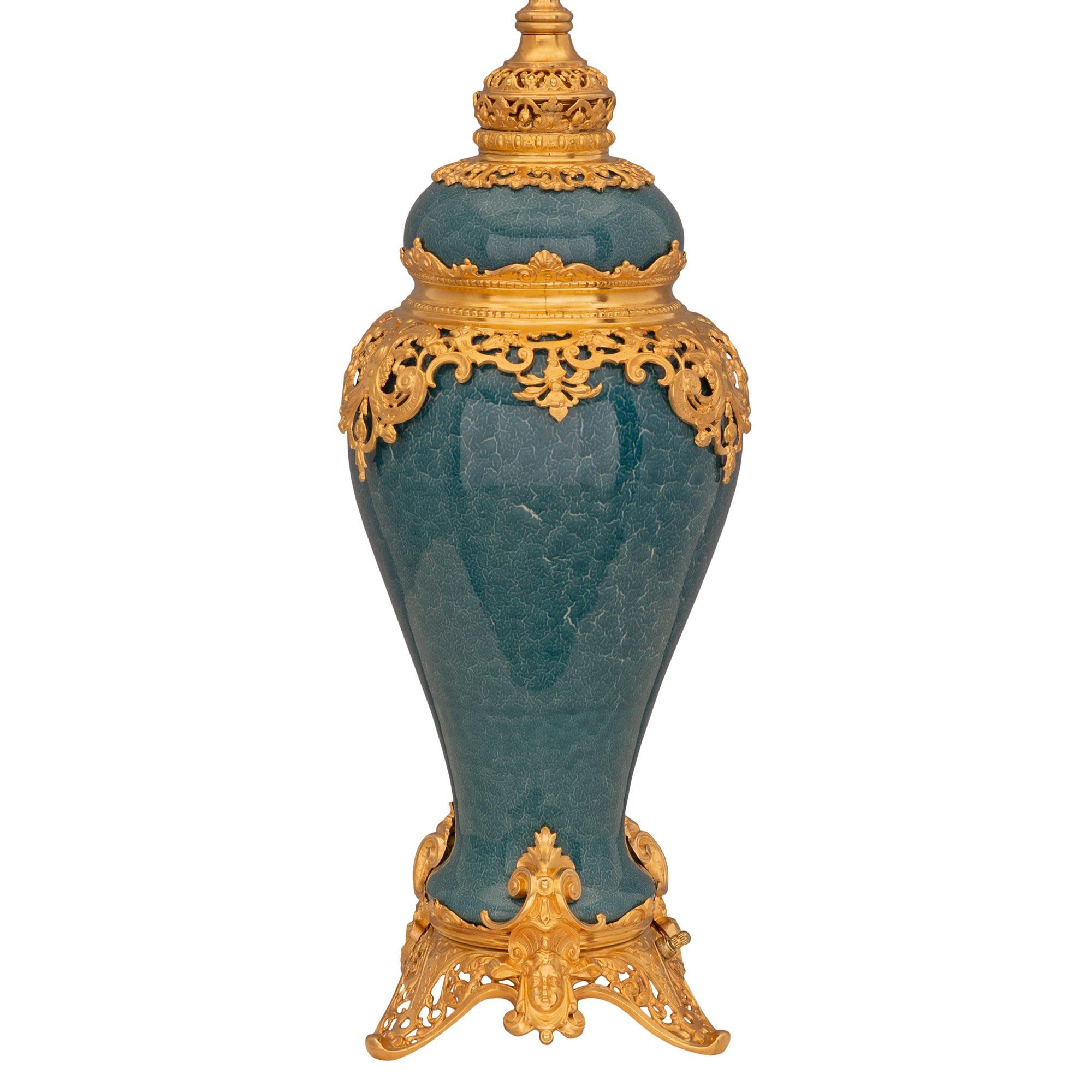 A striking and very unique pair of French and Asian collaboration 19th century Régence st. porcelain and ormolu vases mounted into lamps. Each lamp is raised by a finely detailed pierced ormolu base with elegant scrolled foliate designs and richly