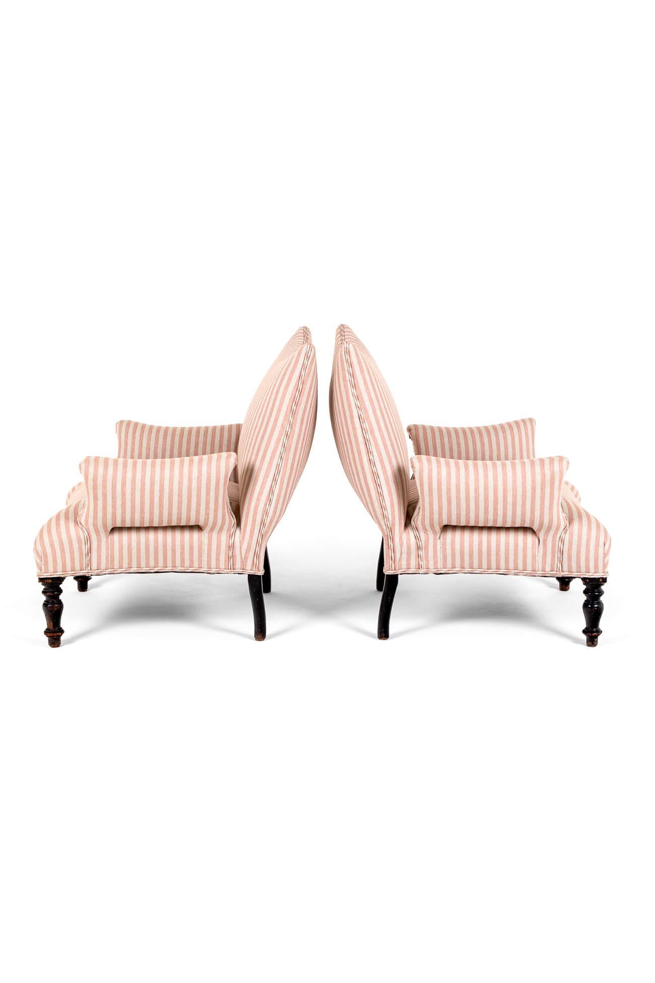 A interesting pair of unusual 19th century French Napoleon III armchairs with sublime concave backs.

The generous seats are accentuated by rectangular splayed arms.

The heavy oak frames are raised on turned ebony legs.

This pair of armchairs has