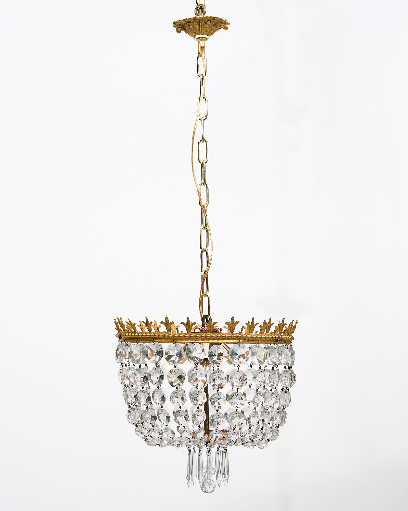 Pair of French antique crystal chandeliers. Finely gilded brass structures with a fleur-de-lys crown. Cut crystal “Cabochons” and pendants. They are newly wired to fit US standards and the current overall height from ceiling is 38.25