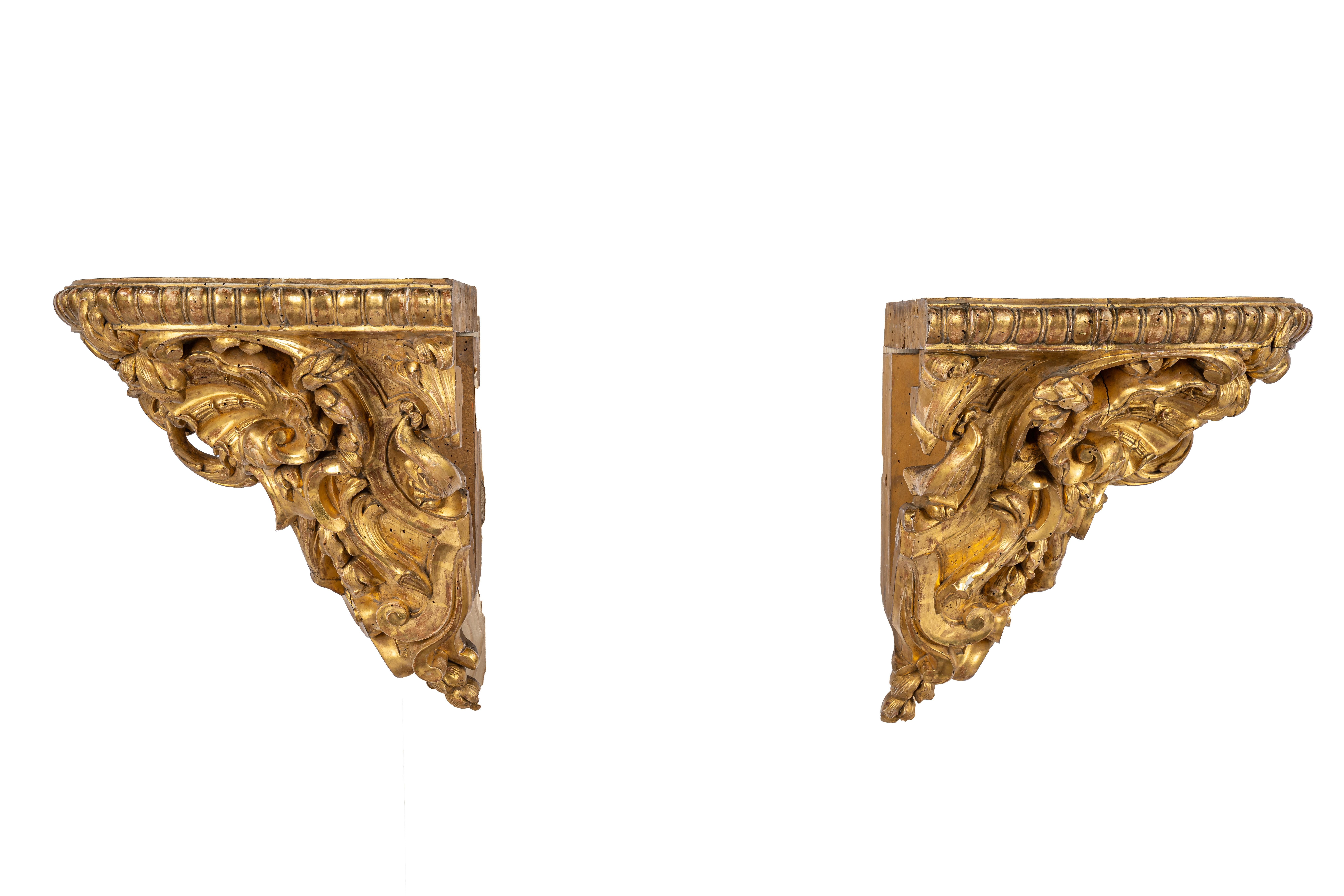 Nous vous proposons ici une superbe paire de consoles d'angle 100% originales, dorées à la feuille d'or et polies, méticuleusement sculptées à la main dans du bois de tilleul massif. Fabriquées dans le sud de la France vers 1710, ces consoles sont