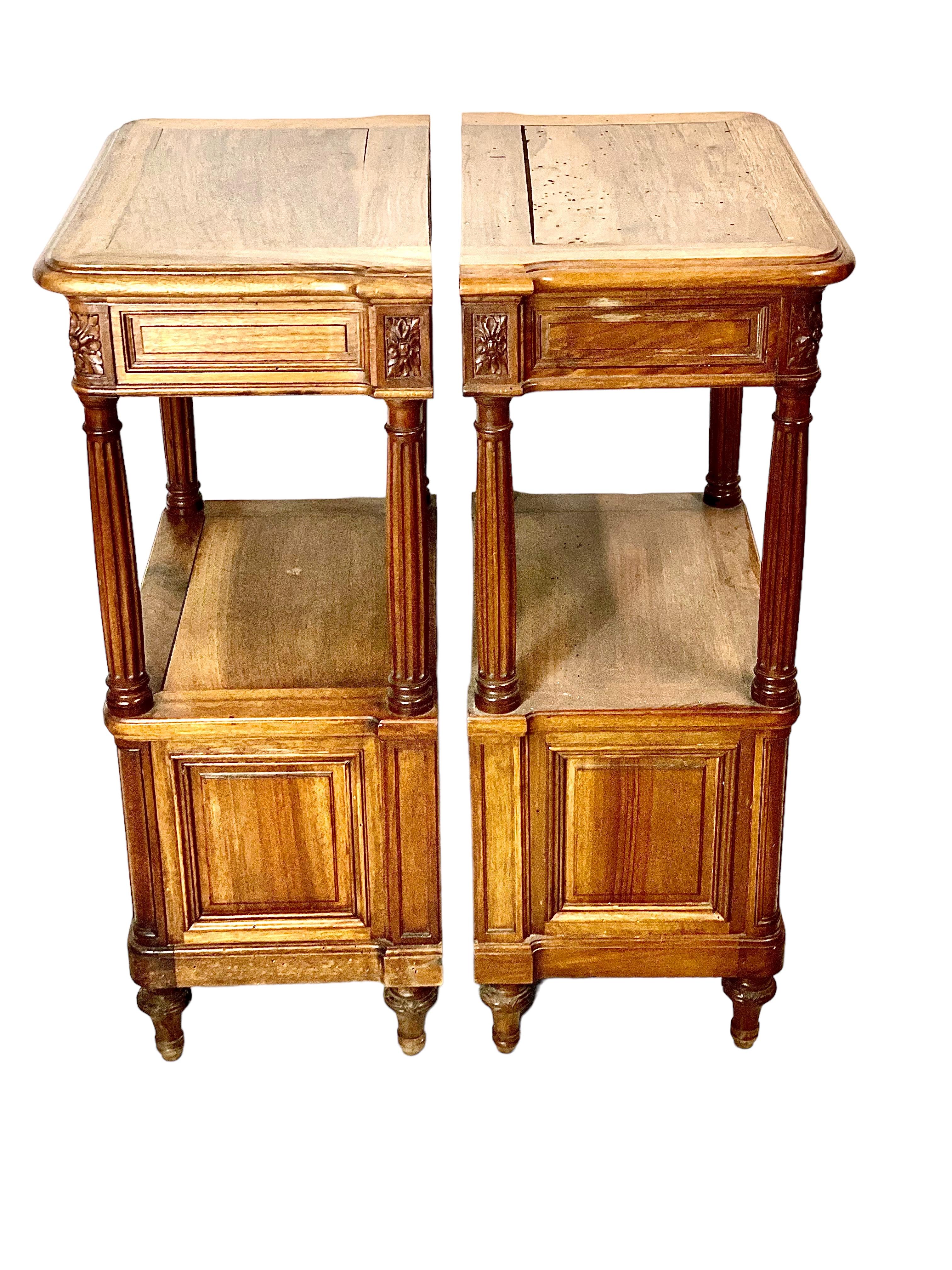 A superb matching pair of moulded and sculpted wood bedside cabinets. Each has a shaped and polished top, with a slim and intricately decorated trinket drawer below. Fluted supports reach down to a lower storage compartment, the door of which is