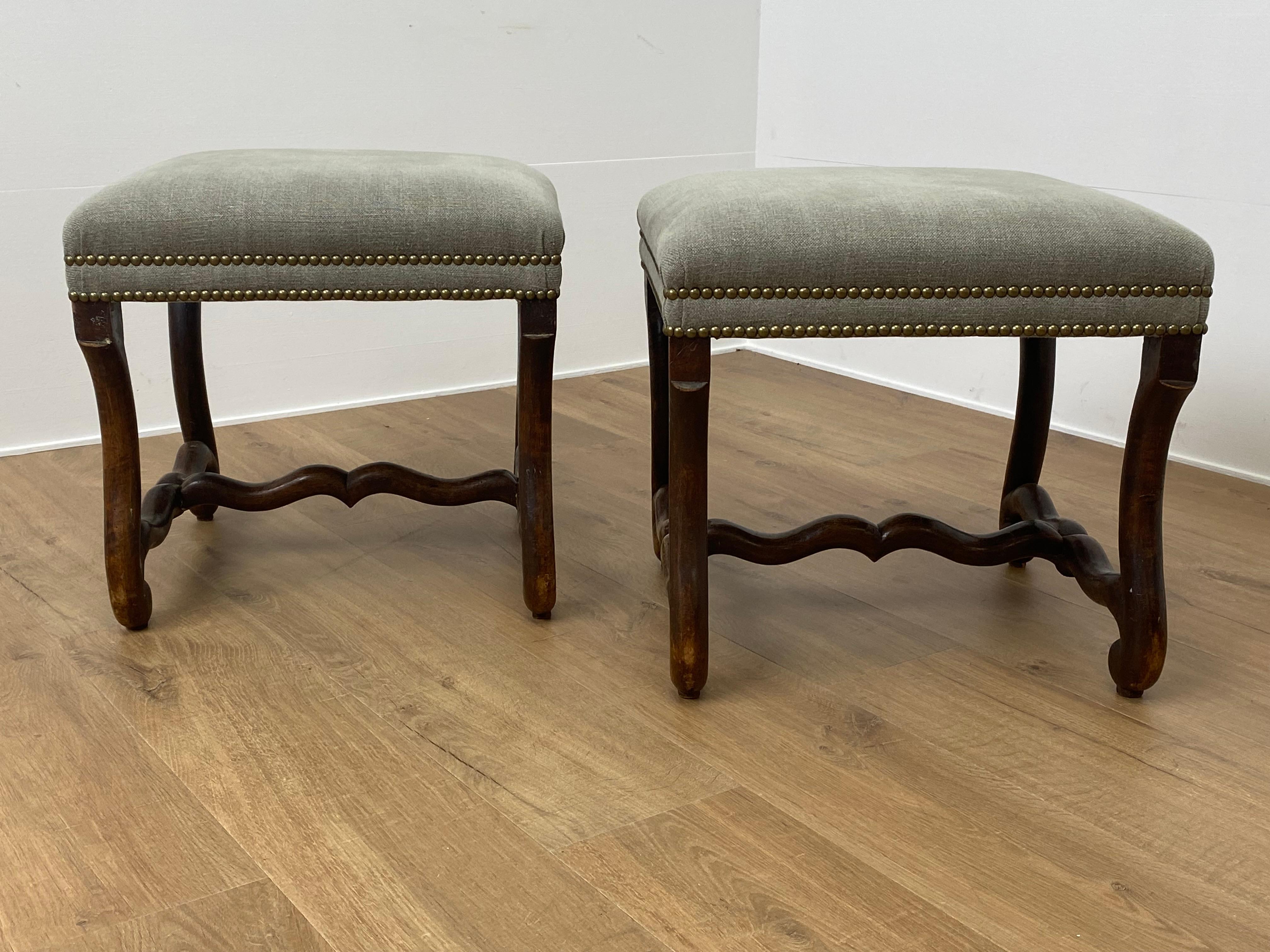 Elegant Pair of French Footstools in Louis XIII Style,
good patina and wear of the Walnut,
new upholstery in a Green Fabric finished with Copper Nails,
very decorative pair of Footstools