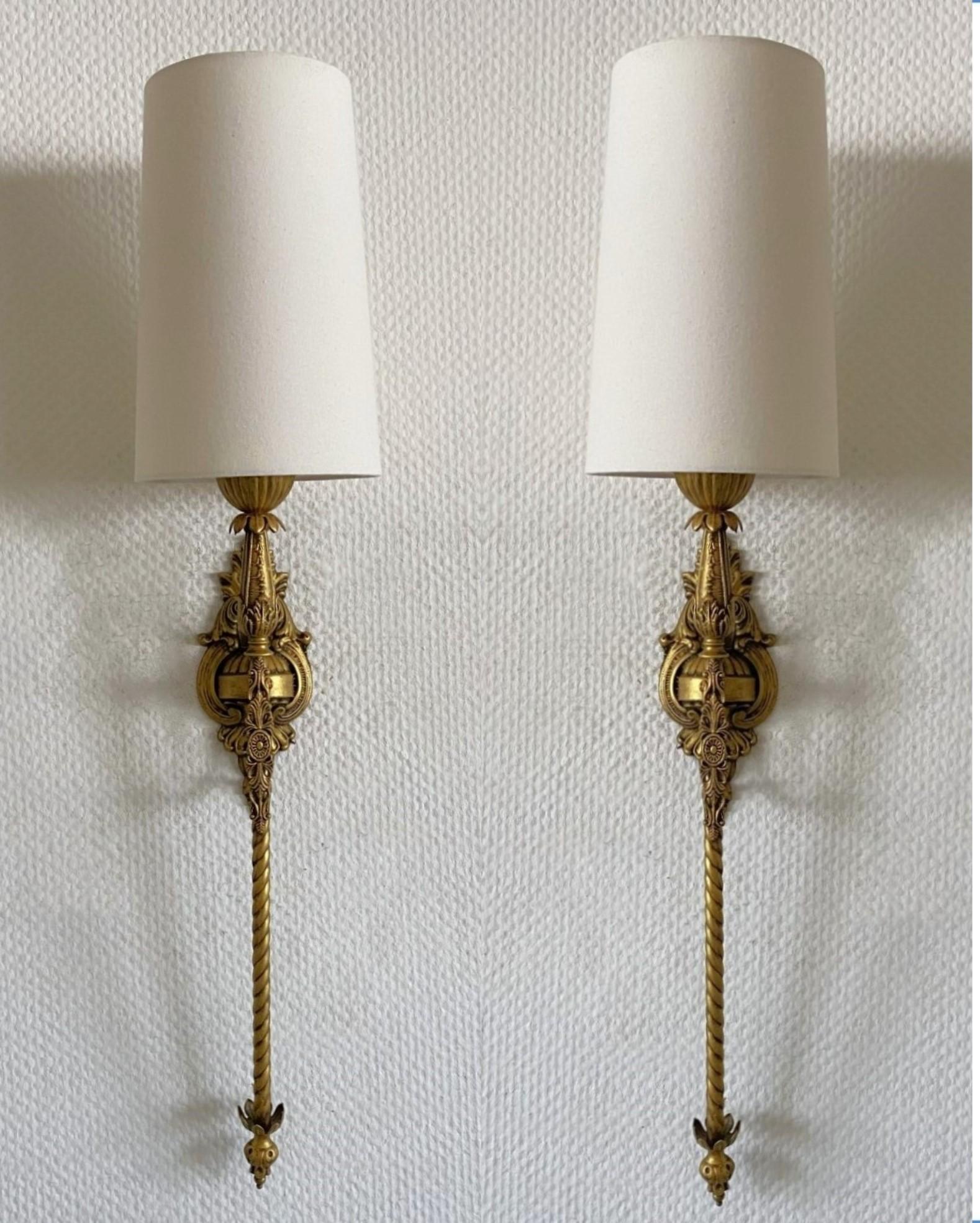 Pair of superb tall Art Deco bronze wall torchieres sconces or wall lanterns richly decorated with fine details from a  mansion in South of France, 1930s. The wall torchieres had been converted to electric wall lights at a later time. Each sconce