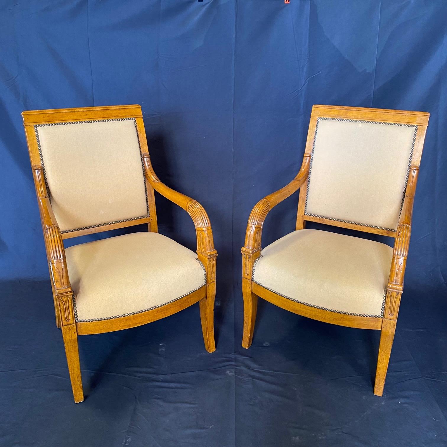 This set of two elegant Empire arm chairs stand out for their classic simple design and the beautifully shaped front legs. These comfortable and stylish chairs feature a wealth of fine craftsmanship, including classic moulding detailing on the