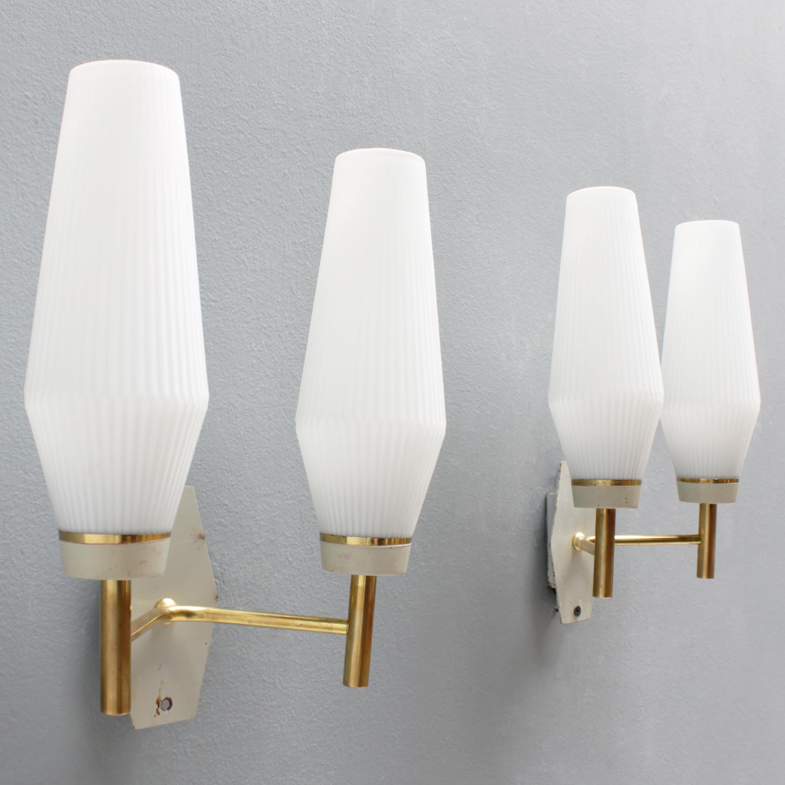 Pair of French wall lights with white glass shades, brass details and white metal wall plates. Manufactured by Arlus, France, period 1950-59. Good condition.
Each fixture has double lamps with two small Edison screw sockets (SES), (E17 14-17 mm)