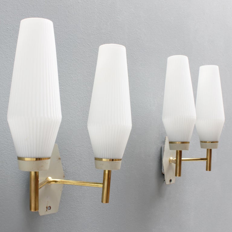 Pair of French wall lights with white glass shades, brass details and white metal wall plates. Manufactured by Arlus, France, period 1950-59. Good condition.
Each fixture has double lamps with two small Edison screw sockets (SES), (E17 14-17 mm)