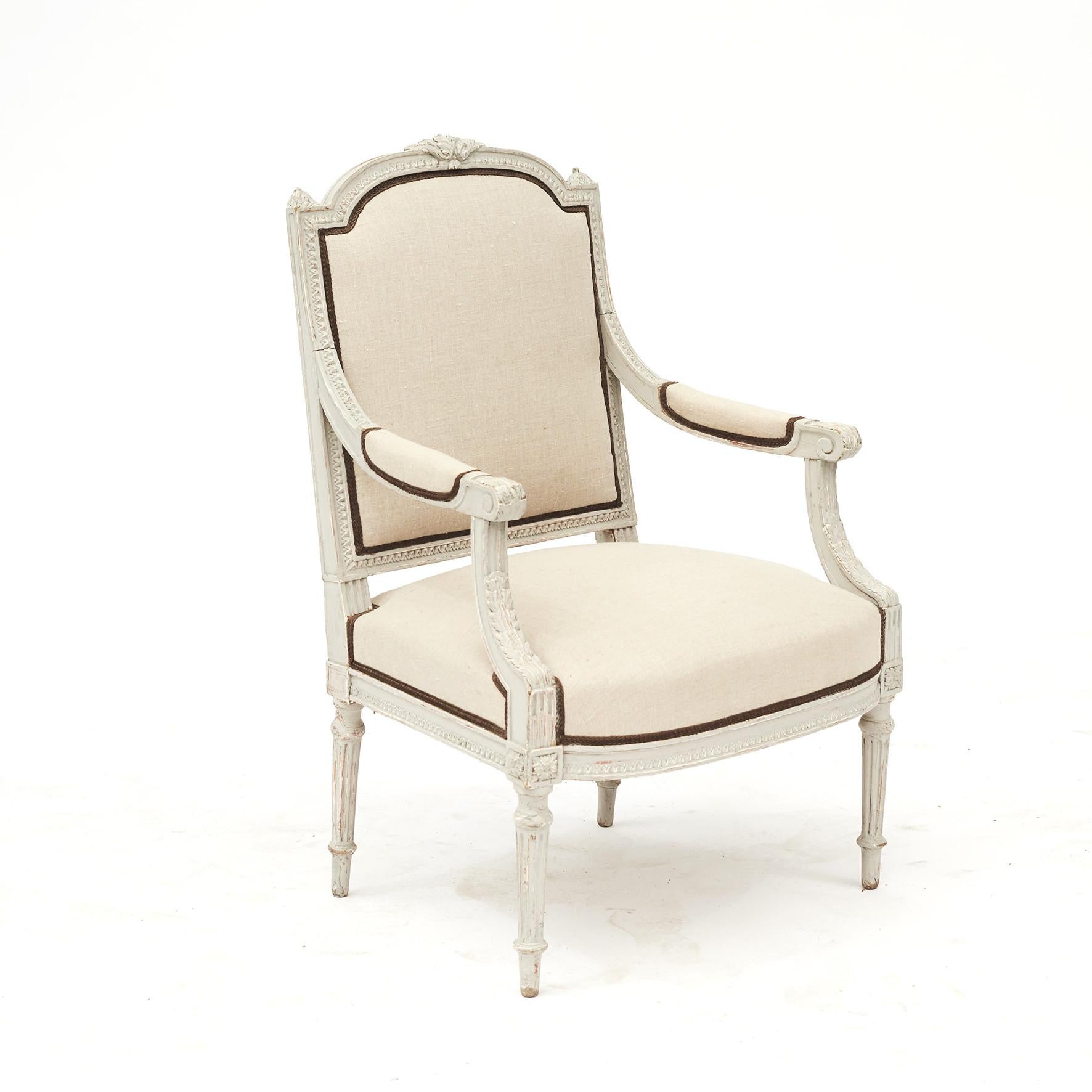 Pair of French armchairs in the style of Louis XVI, 1860-1870.
Carved detailing all along the light grey framework, on fluted and tapered legs.
Upholstered in light canvas fabric with brown trimming.
Sold as a pair.