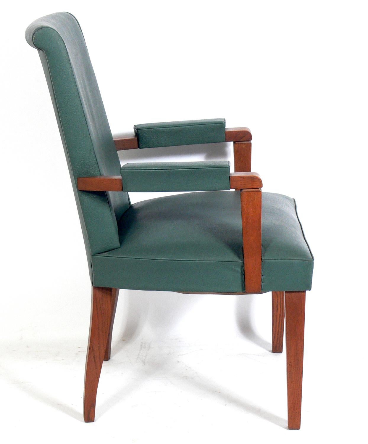 Pair of French Art Deco Oak arm chairs, attributed to Andre Arbus, French, circa 1940s. They retain their original naugahyde upholstery. Measurements: 39