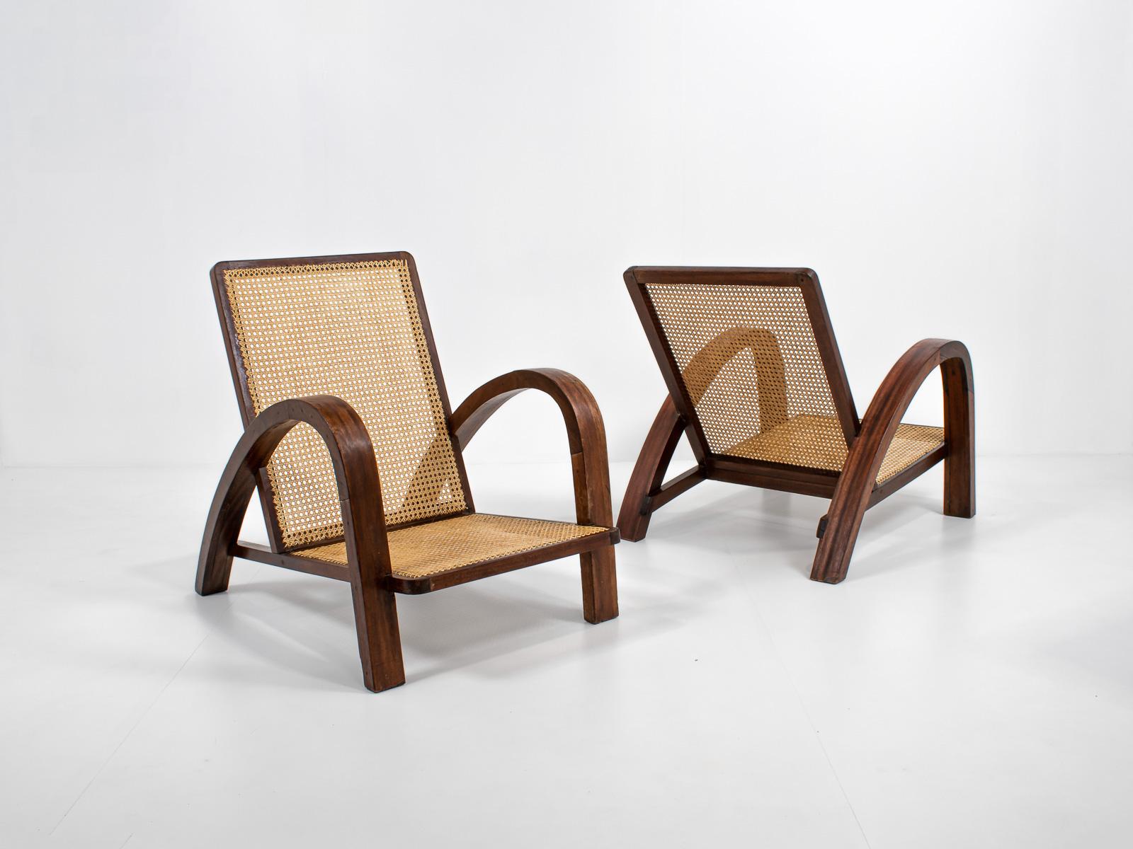 Amazing pair of French art deco armchairs. The frame of the chairs is in a warm, rich brown, which contrasts beautifully with the cane. Very classy look because of the sculptural frame. Both chairs are in great condition. 

Important to notice:
