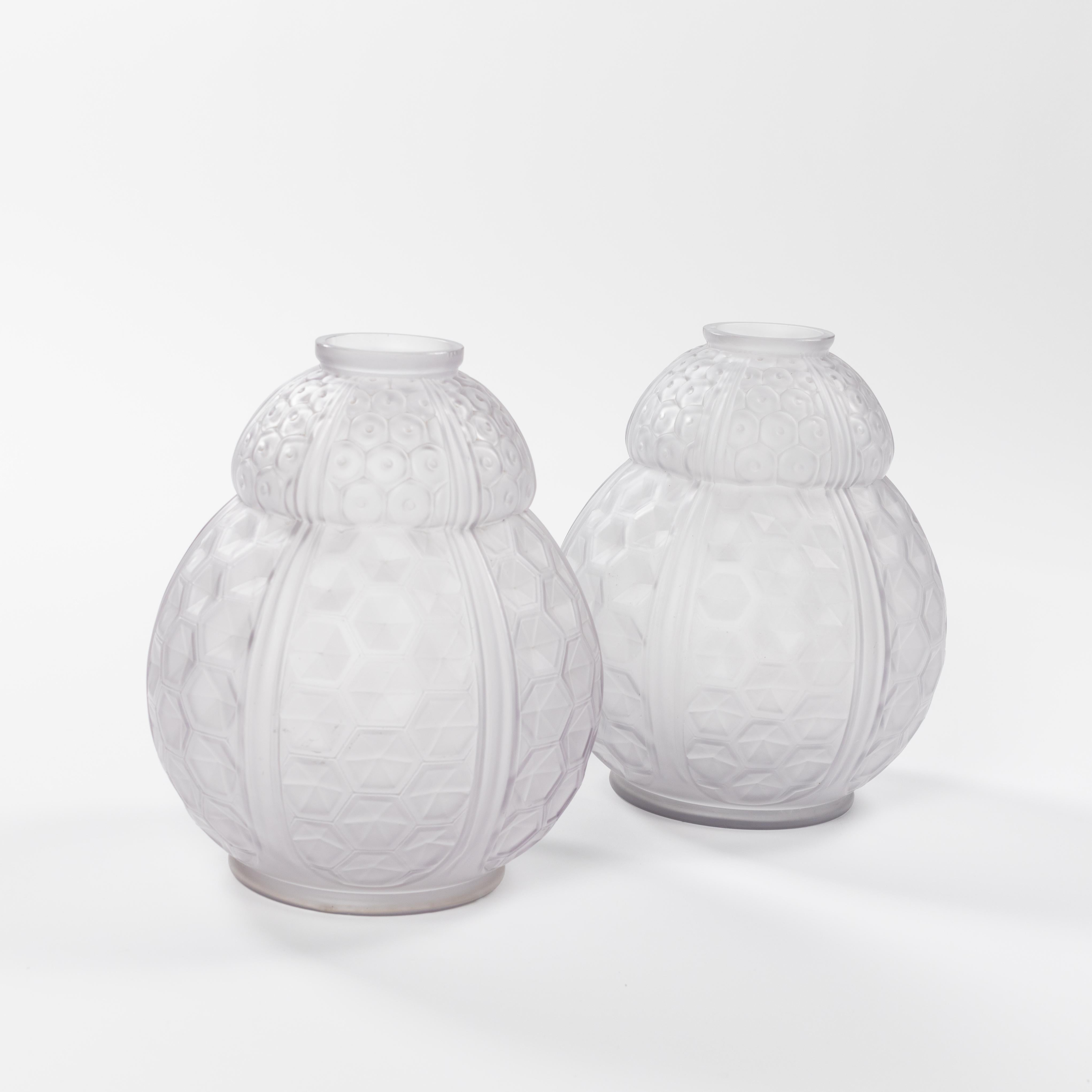 Pair of very decorative, bulbous pressed art-glass vases by Oreor, signed. 
Pressed glass with plastic geometric art deco motif in almost transparent glass and relief-like outer structure.
The color has a light violet-grey tone, the plasticity of