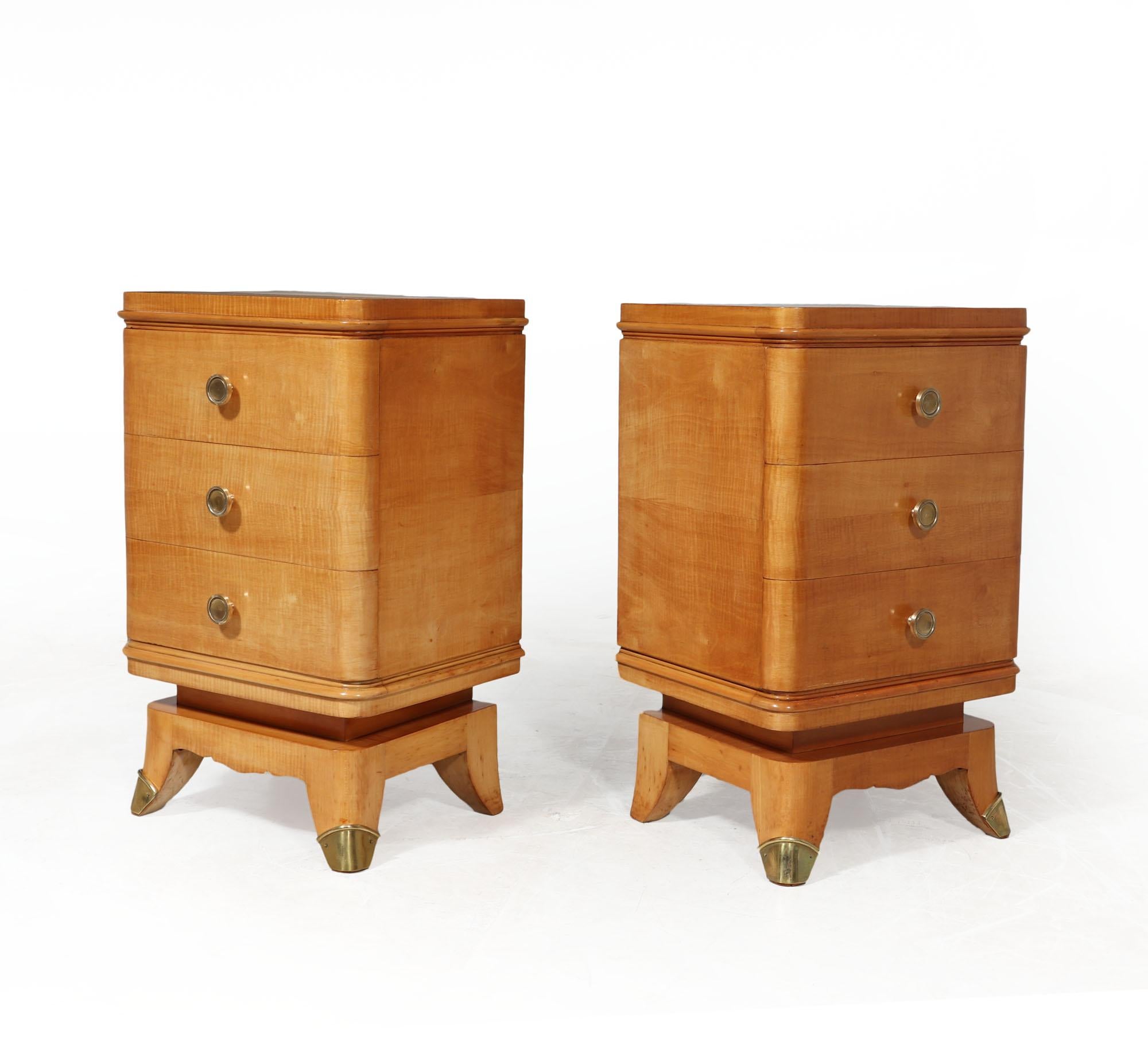 PAIR OF ART DECO BEDSIDE CHESTS 
An exceptional quality pair of three drawer bedside chest of drawers each having three drawers rounded corners and beading detail and raised on a short sabre for legged base with brass sabots The chests have been