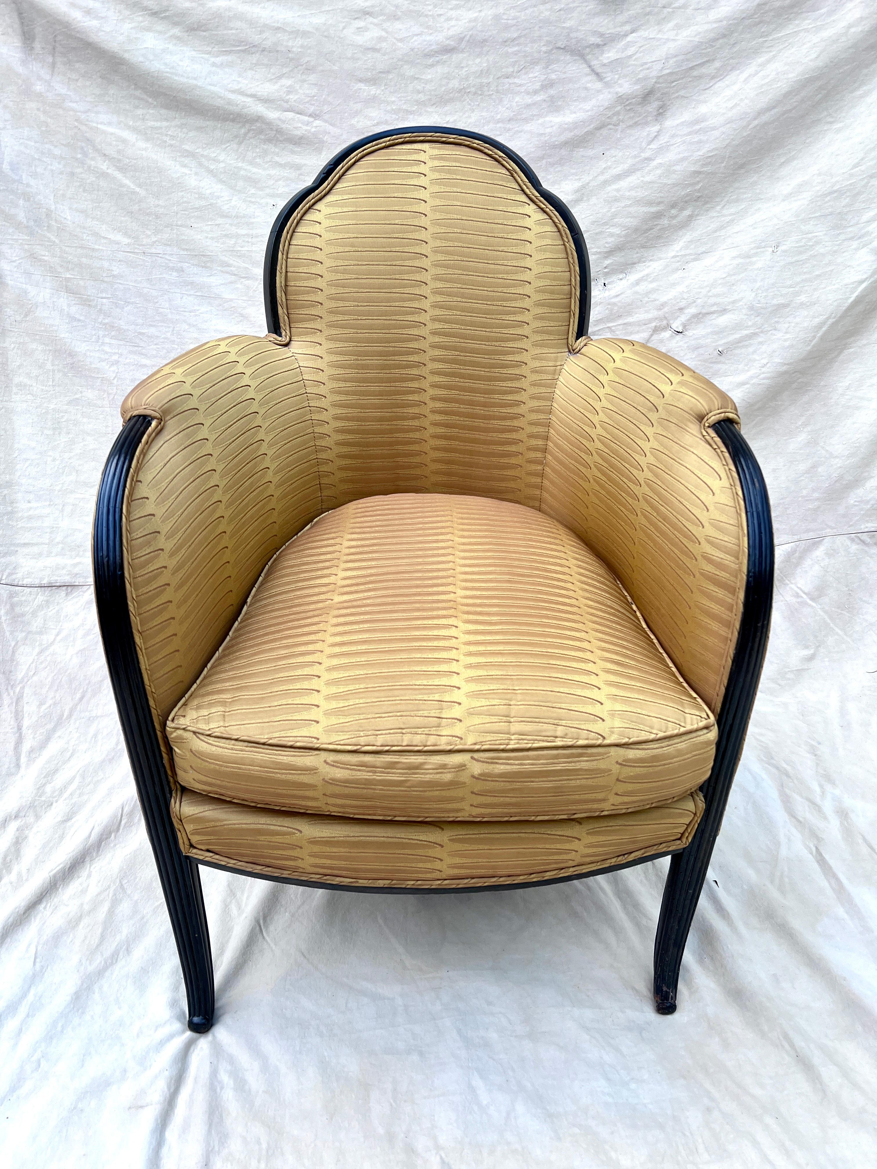 Une superbe paire de chaises bergères françaises dans le style de Paul Follot.  La paire présente un magnifique dossier festonné, un bras gracieusement incurvé, sculpté à la main, qui se prolonge jusqu'à une branche effilée.  Les cadres sont en