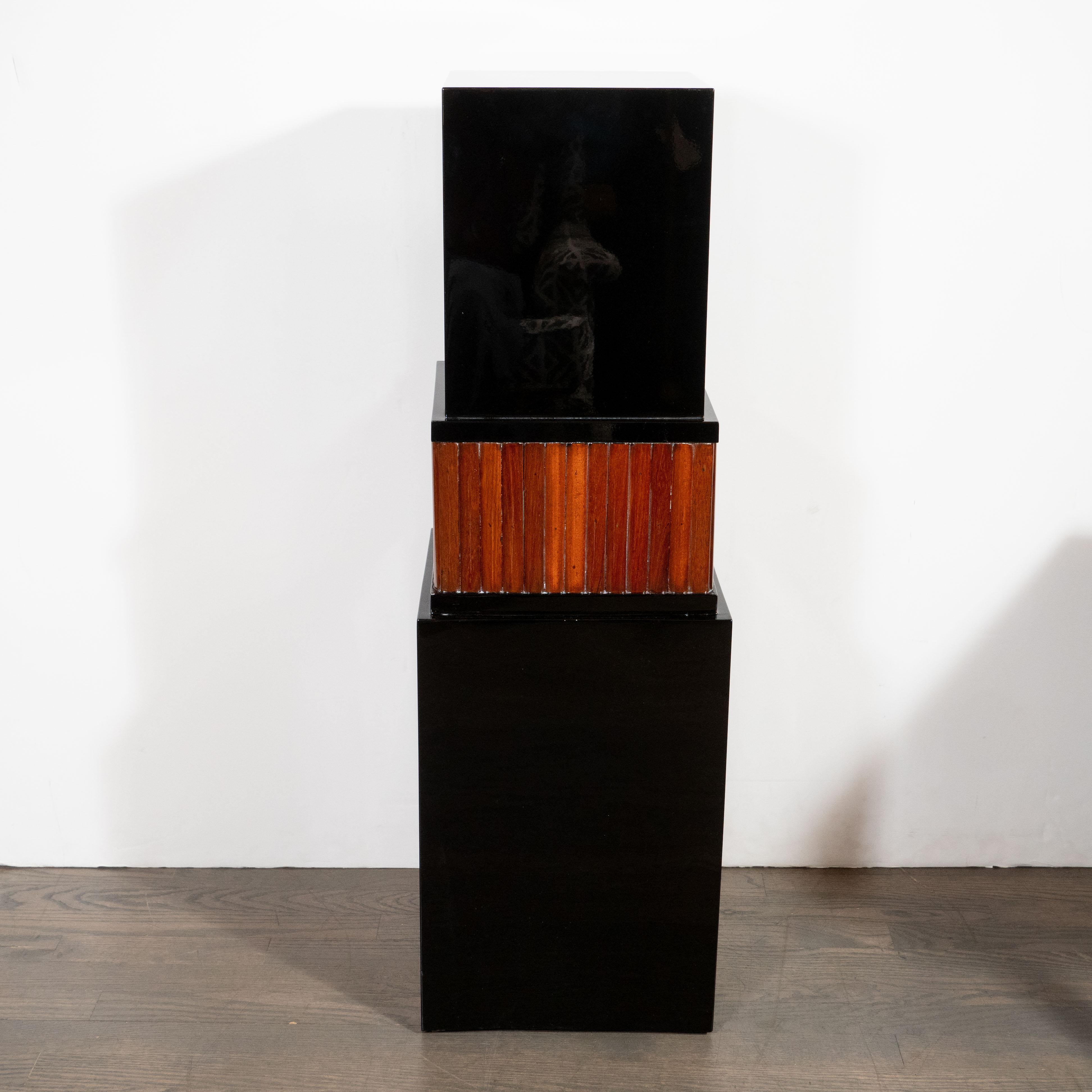 This elegant skyscraper style Art Deco pedestal was realized in France, circa 1930. They offer three tiers diminishing in area to their apex. The top and bottom tiers are realized in lustrous black lacquer while the central tier is composed of