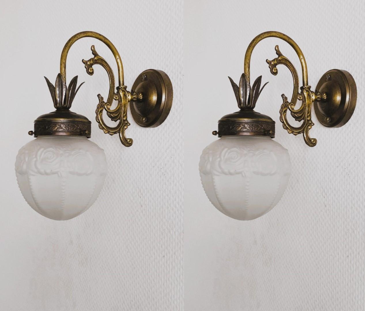 Pair of bronzed brass wall lights with frosted art glass globes, for indoor or covered outdoor use, France, 1930-1939. All wall sconces are in very good condition, beautiful patina, no ships or cracks, rewired. Each sconce takes one Edison E14 screw