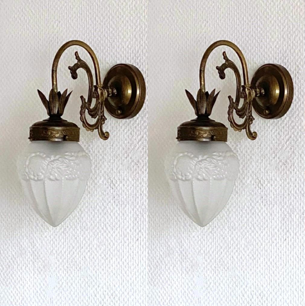 Pair of bronzed brass wall lights with frosted art glass globes, for indoor or covered outdoor use, France, 1930-1939. All wall sconces are in very good condition, beautiful patina, no ships or cracks, rewired. Each sconce takes one Edison E14 screw