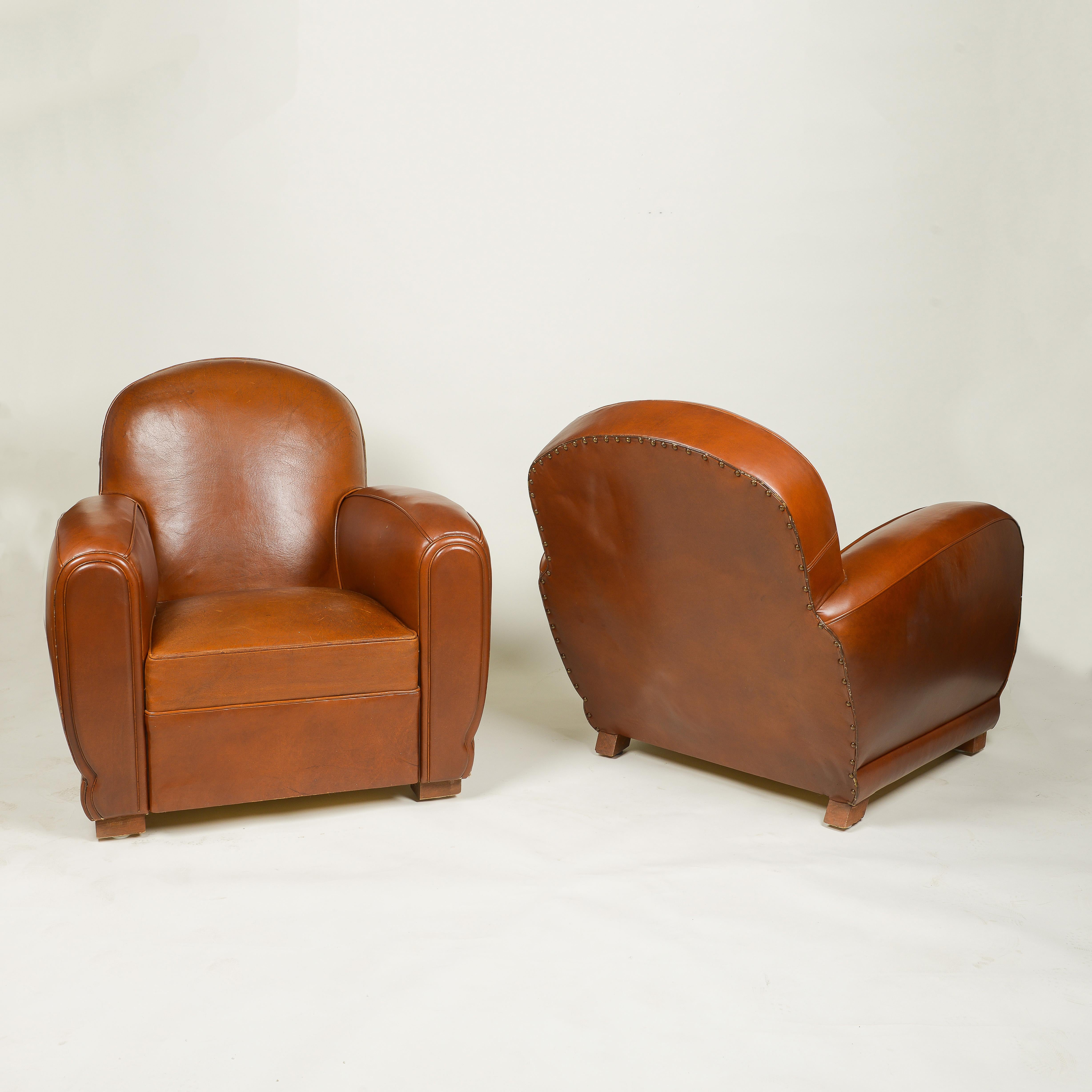 Each with rounded, angled back; on shaped maple feet; not overscaled; very attractive patina to leather.