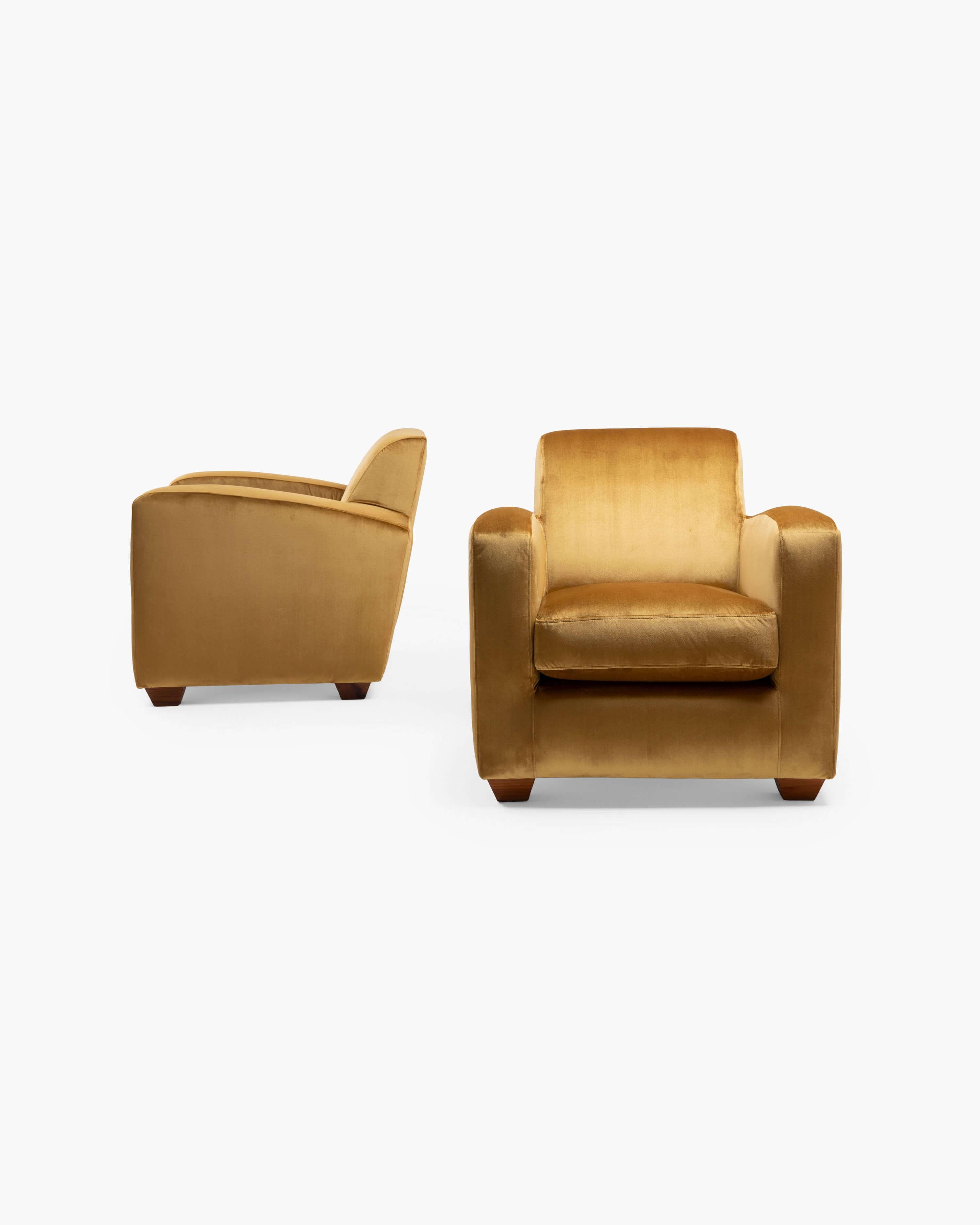 Les larges assises inclinées de ces fauteuils club Art déco français offrent à la fois confort et caractère avec leurs accoudoirs arrondis et leur large silhouette. Tapissée de velours doré, la paire fait écho aux qualités de la vision moderniste du