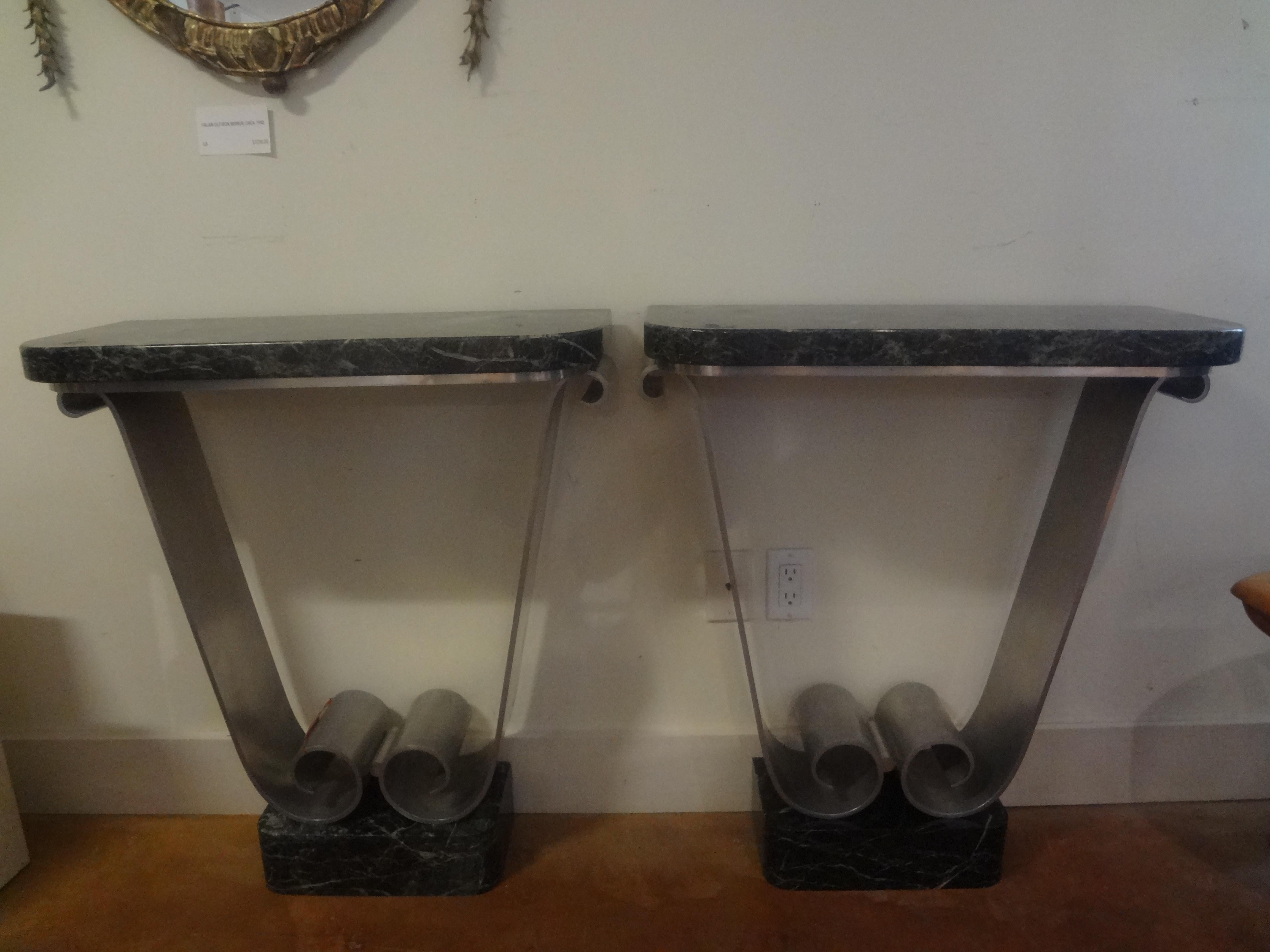 Pair Of French Art Deco Console Tables Attributed To  André Arbus.
These stunning French Art Moderne or French Art Deco u-shaped console tables are constructed of brushed aluminum with 4 inch thick bases and 1.75 inch thick marble tops.
These chic
