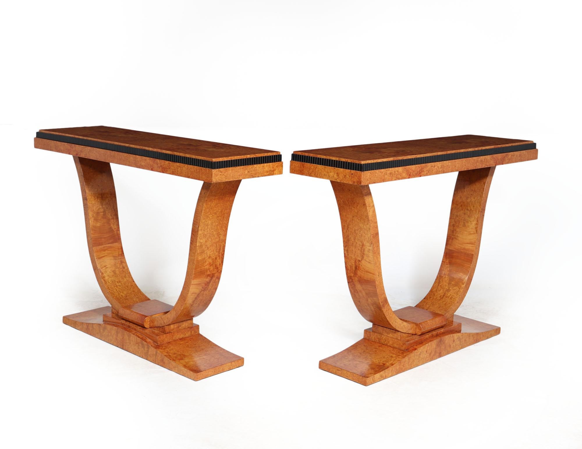 An exceptional quality and for pair of console tables produced in amboyna in France in 1925, having shaped base and u shaped uprights with reeded ebonies detail around the top step, extensive burr and figuring to the veneers and great colour the se