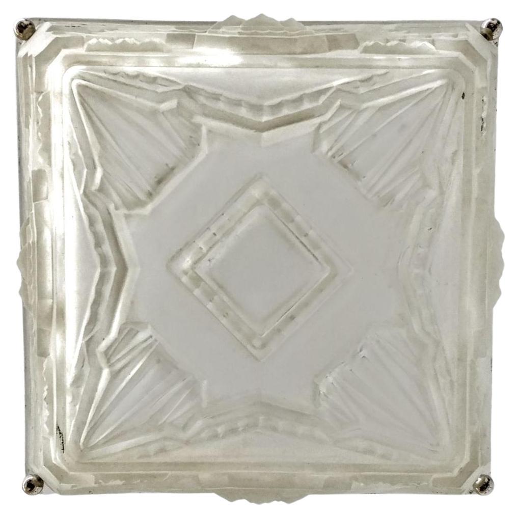 Französischer Kronleuchter in quadratischer Form des Art Déco, geschaffen von Marius Ernest SABINO (1878-1961). Der Schirm ist mit den typischen geometrischen Motiven des französischen Art déco verziert. In einem mattierten Glas mit polierten