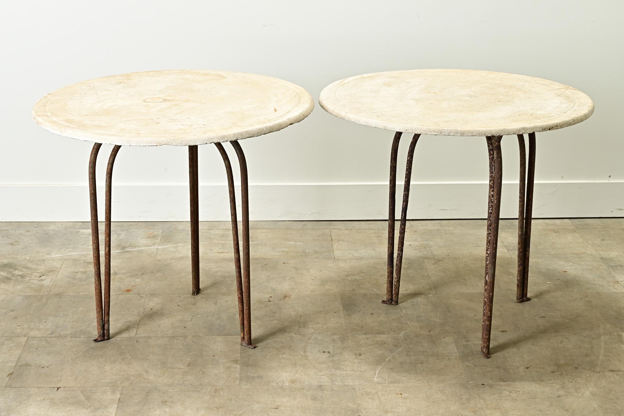An impressive pair of Art Deco style round marble top tables. Married over time, the worn marble top and iron base pair well together. The white marble top is smooth and has a lot of patina, the iron base has a raw iron finish and boosts lots of
