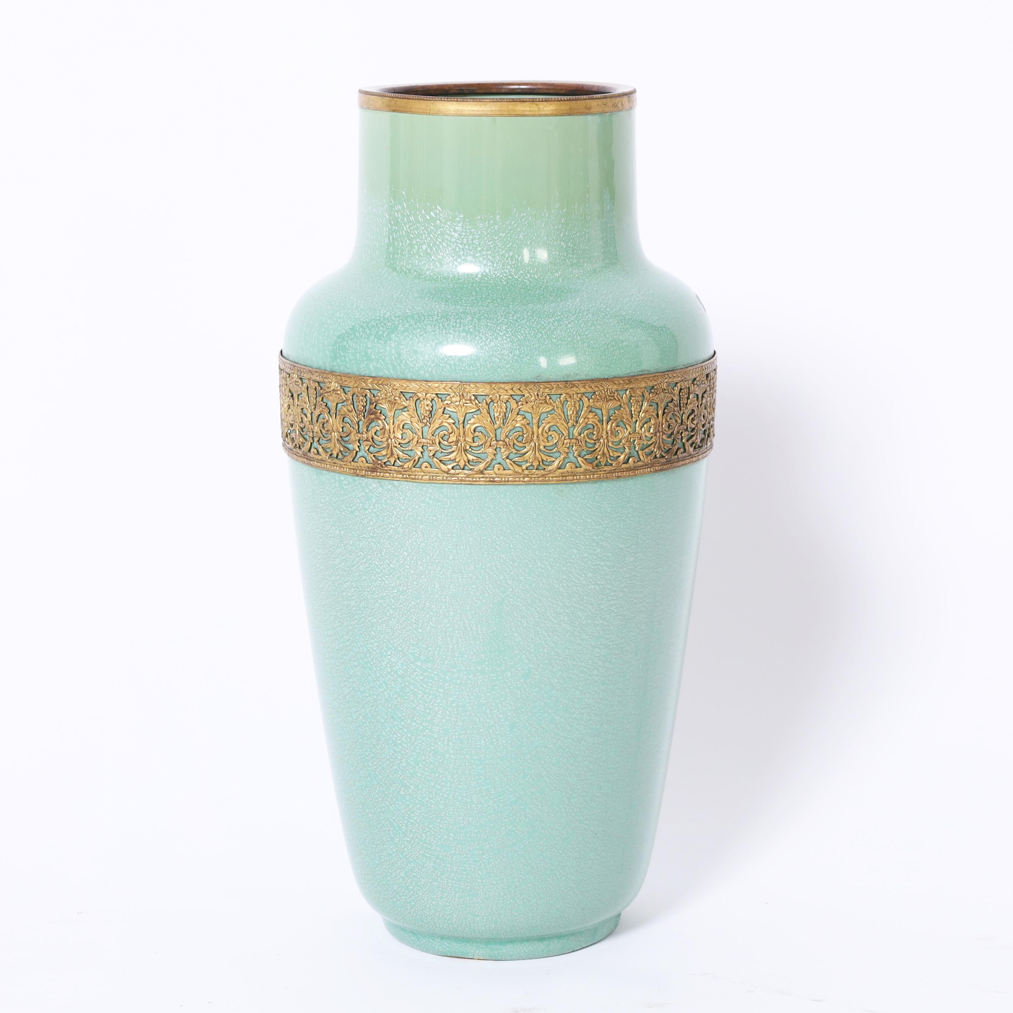 Paire de vases en poterie art déco de forme classique, décorés d'une glaçure verte, d'un bord en laiton et d'une manchette florale stylisée. Signé Sarrequemines France sur les fonds. 