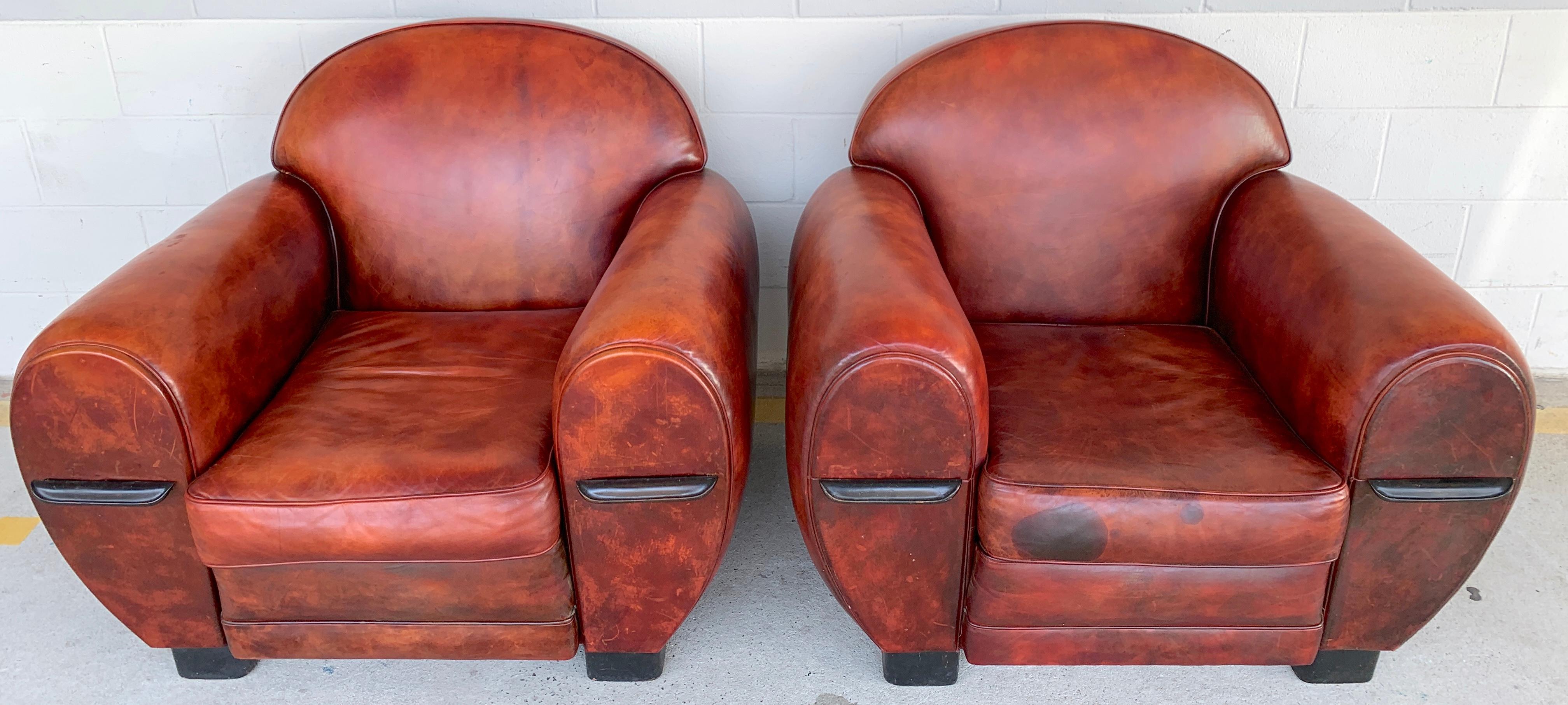 Great pair of French Art Deco leather club chairs, each one of substantial size a scale, upholstered in beautifully patinated calfskin leather, complete with two pullout / pull-out 8