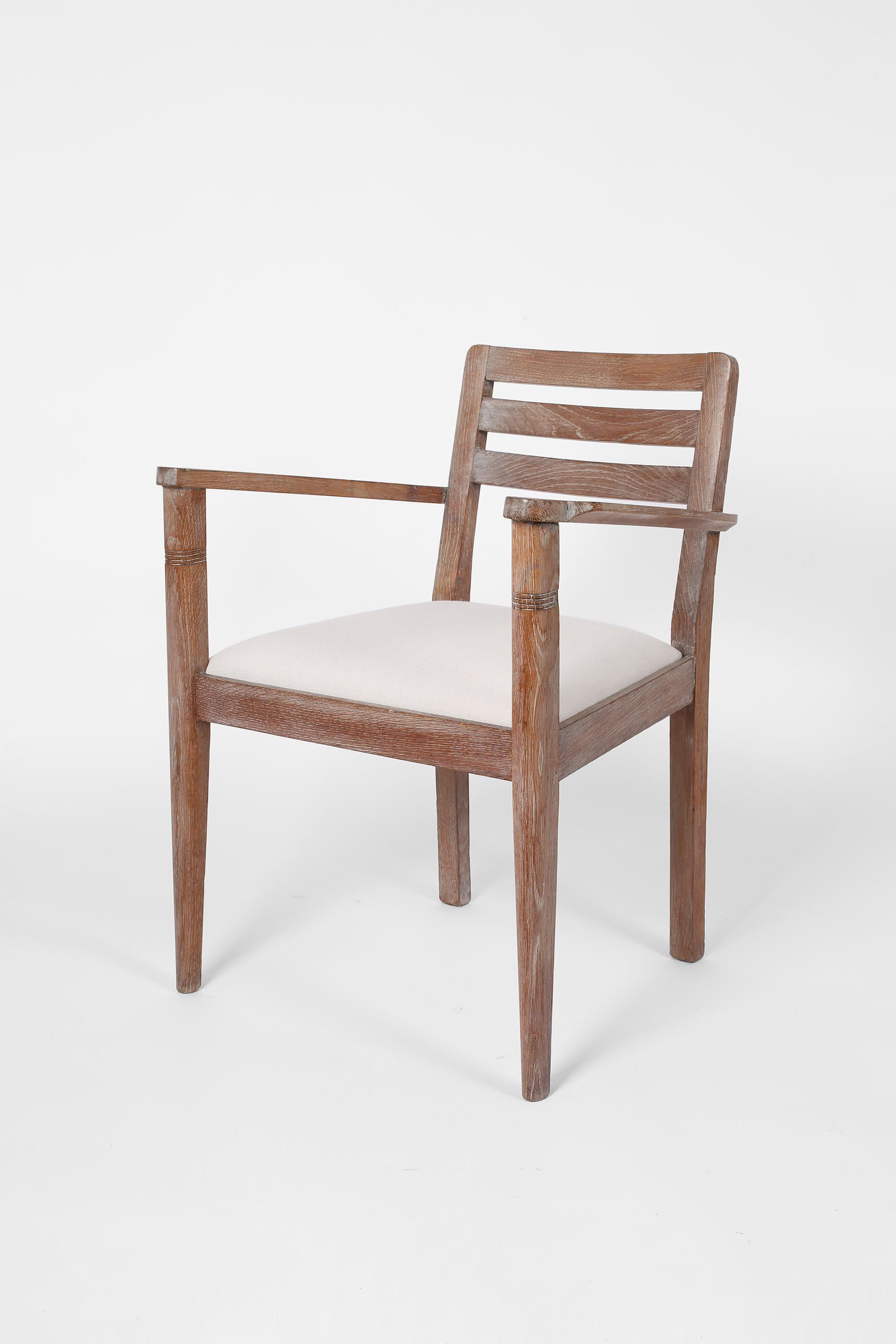 Une paire de fauteuils Art Déco en chêne chaulé, avec des sièges tapissés en lin blanc cassé texturé. Français, vers les années 1930.