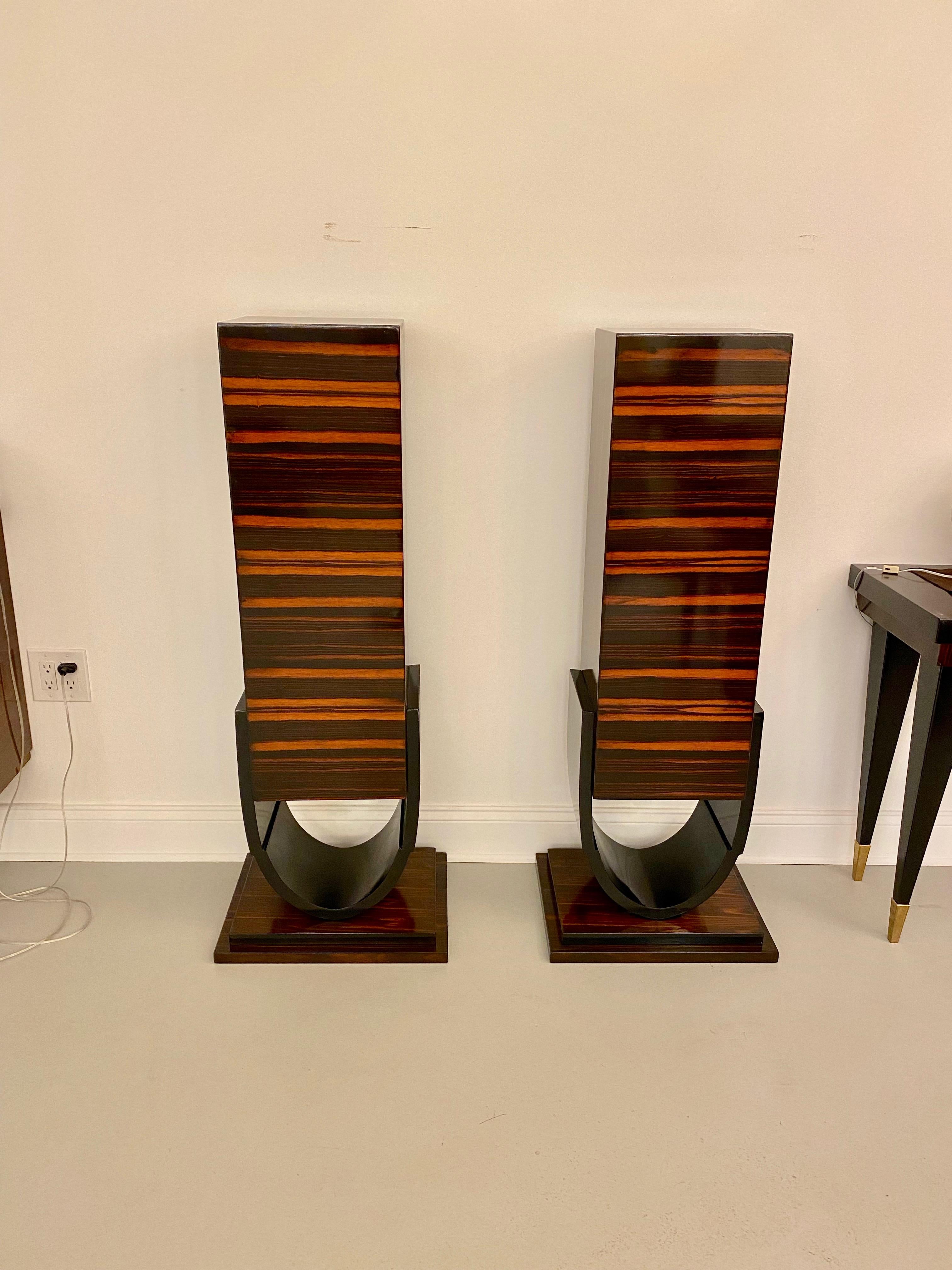 A spectacular pair of French Art Deco Macassar ebony pedestals, circa 1920s. Black lacquer tulip form base. These pedestals are Macassar ebony on all sides and can be shown anywhere in a room. They can be viewed from all sides. High gloss finish.