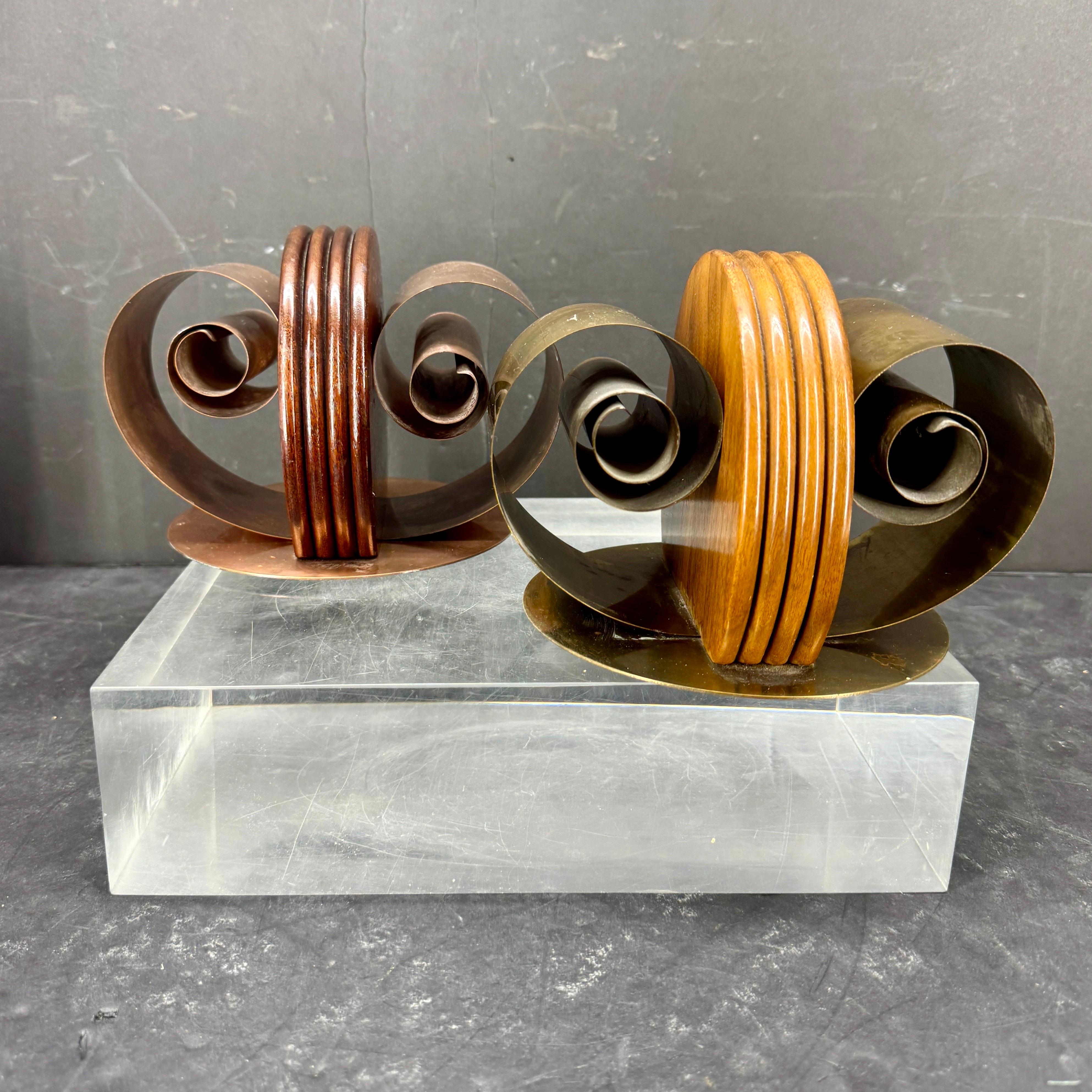 Very substantial and versatile pair of art deco bookend sculptures. These sturdy vintage bookends have been crafted into a striking scroll design with multiple uses for the modern bookshelf. Use this pair together or individually as desk items or