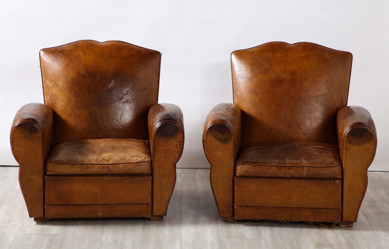 Pair of 'Moustache' French Art Deco leather club chairs, circa 1920s with spectacular soft and supple original cognac leather and original horse hair filling. The pair are stunningly handsome, with a century full of character and charm. Extremely