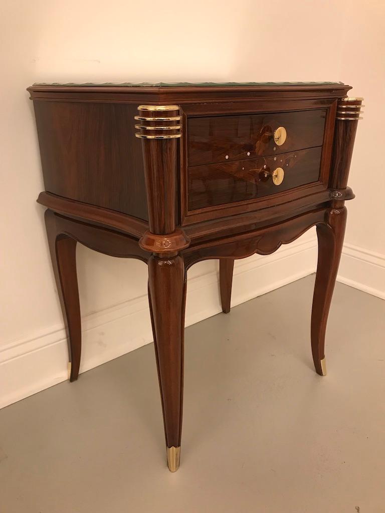 A pair of French Art Deco side tables in the manner of Jules Leleu, circa 1930s. Beautiful rosewood with mother-of-pearl and floral marquetry. Stunning brass hardware accenting the wood beautifully. Having mirrored tops. The tables have been