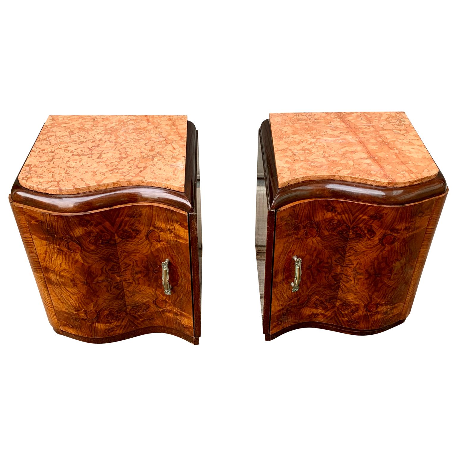 A charming pair of French nightstands or small night tables in walnut veneer wood and original hardware. The stone top is pink travertine.
This set is an honest pair, meaning that the set has left and right facing doors towards the cabinets, making