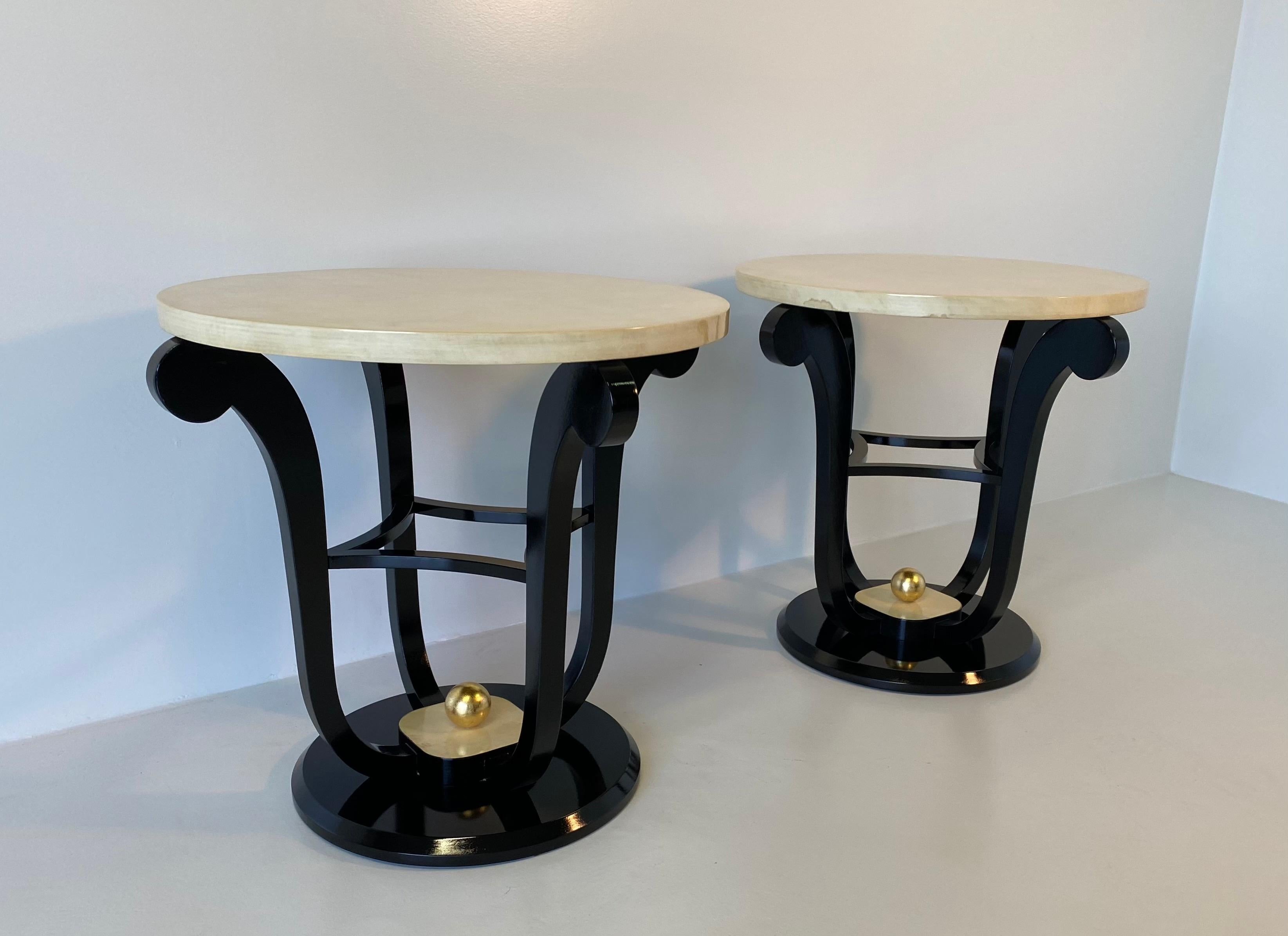 Pair of French Art Deco style coffee table with top in parchment leather and black lacquer.
The central sphere is in solid wood covered with gold leaf.
Totally restored.