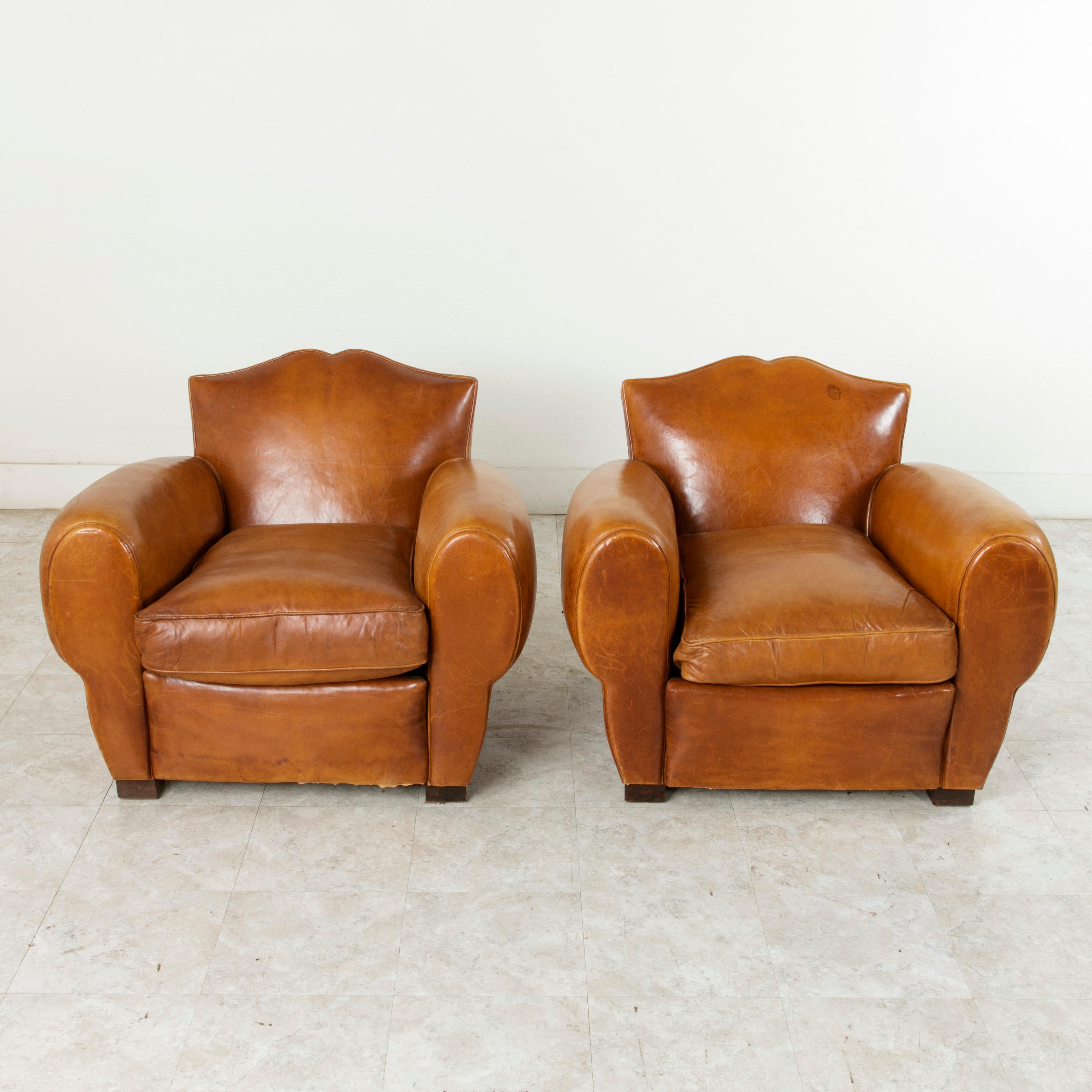This pair of mid-20th century French Art Deco period moustache back club chairs are in wonderful condition. Originally in the entryway of an elderly couple's home in France, these chairs have rarely been sat in. With a design created during the Art