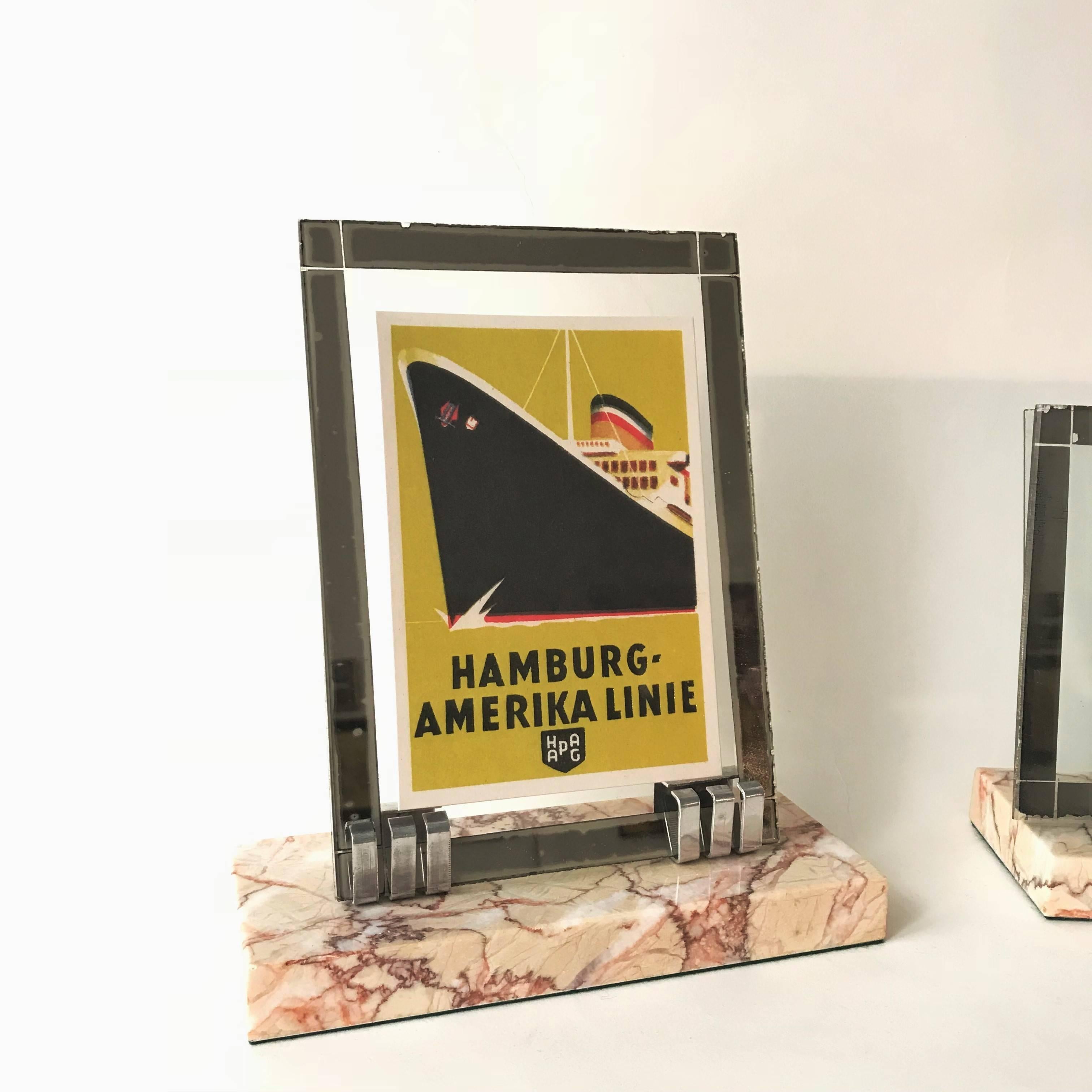 Pair of elegant French Art Deco photo frames featuring a thick solid Rose de Brignoles marble base with two metal claws. The frames are complete, two glass sheets to enclose the picture. The front glass sheets have a mirror frame each. Picture can